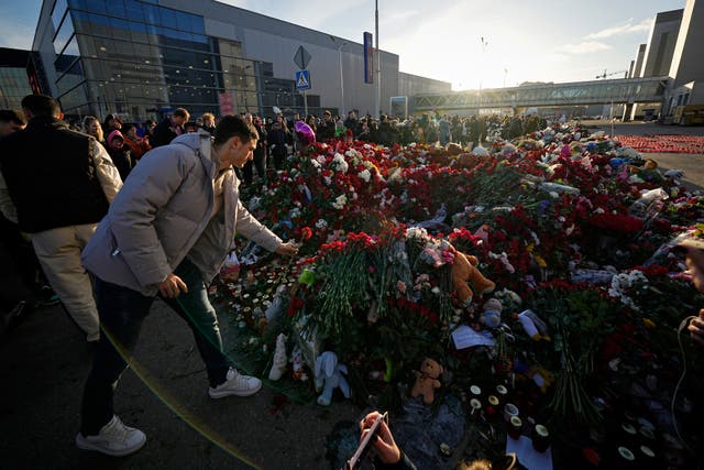 <p>People place flowers at a makeshift memorial in front of the Crocus City Hall on the western outskirts of Moscow</p>