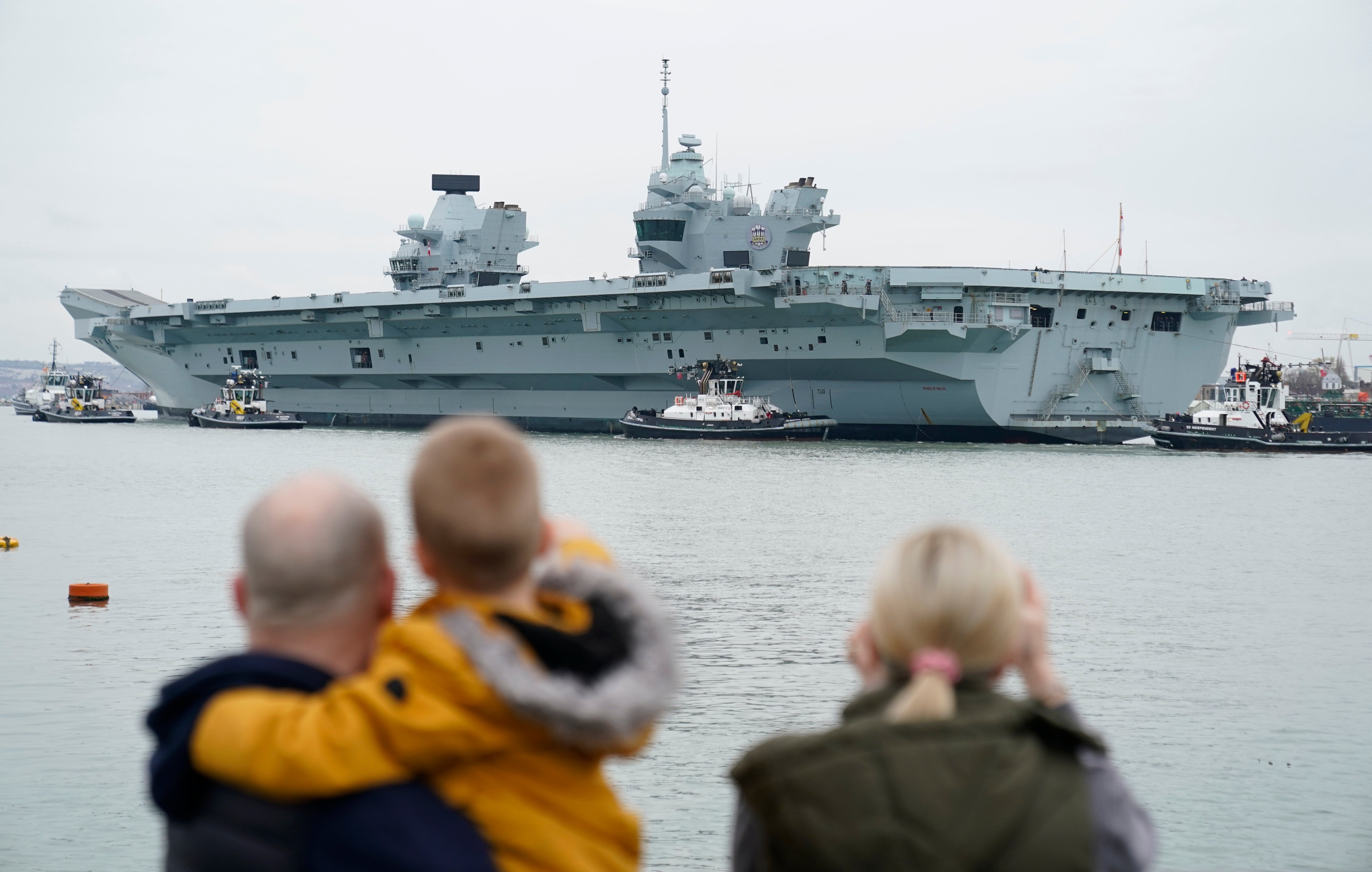 A Royal Navy aircraft carrier returns to her home port of Portsmouth