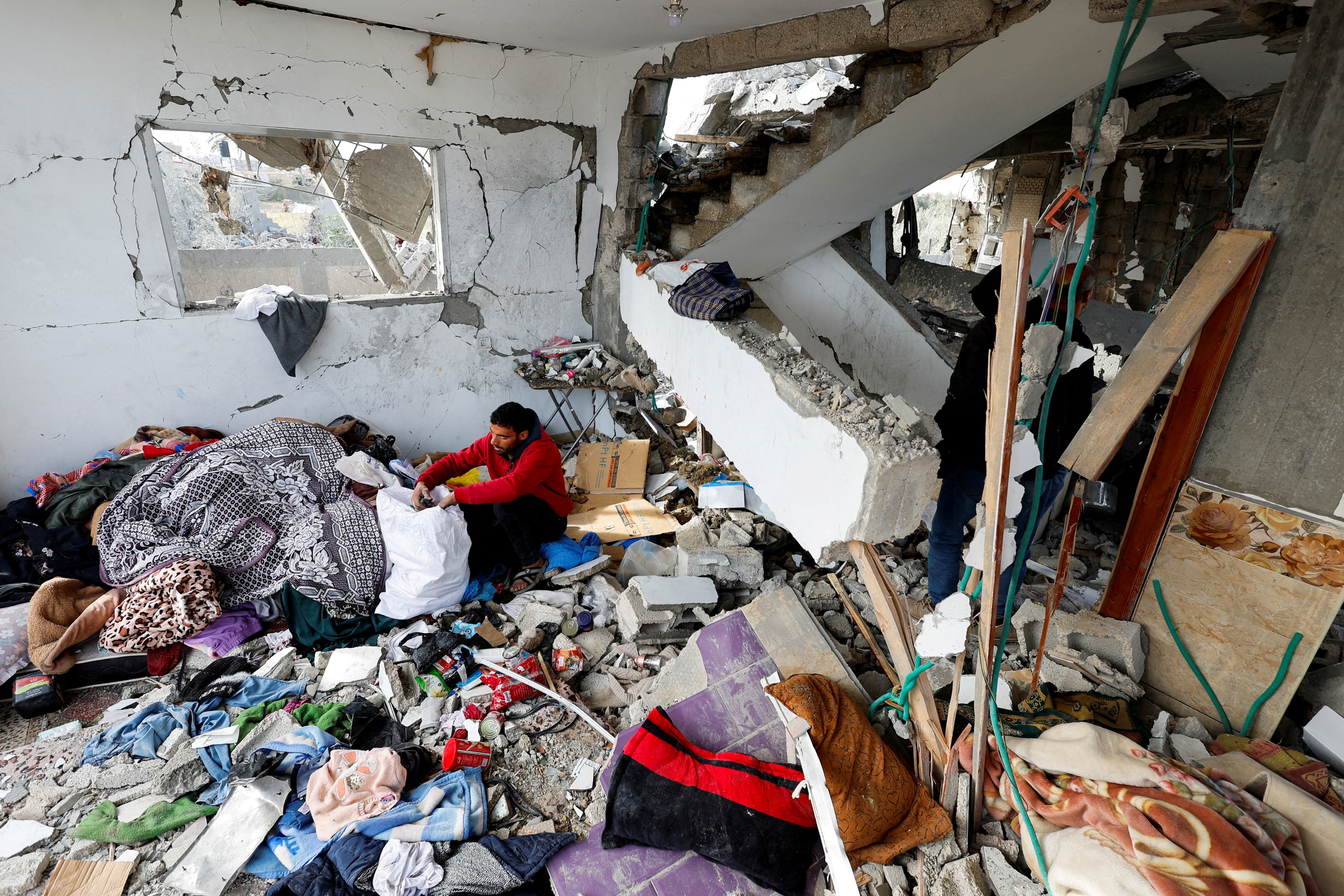 A Palestinian man retrieves belongings from the site of an Israeli strike on a house, in Rafah, southern Gaza