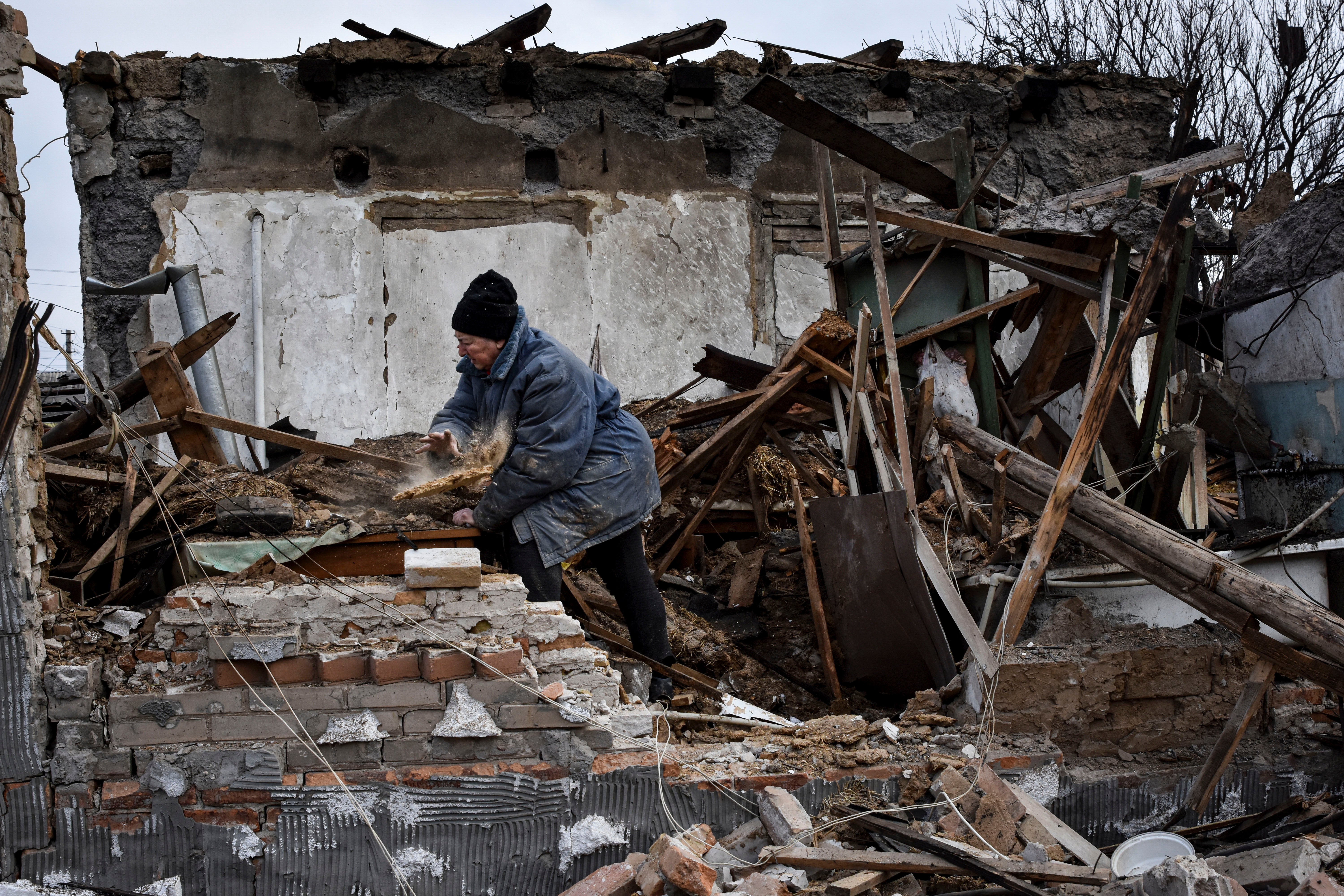 Inna, 71, clears the rubble after her house was destroyed by a Russian drone attack in a residential neighbourhood