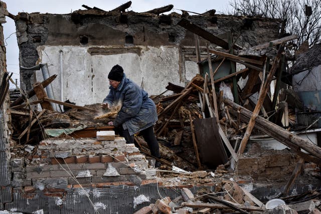 <p>Inna, 71, clears the rubble after her house was destroyed by a Russian drone attack in a residential neighbourhood</p>