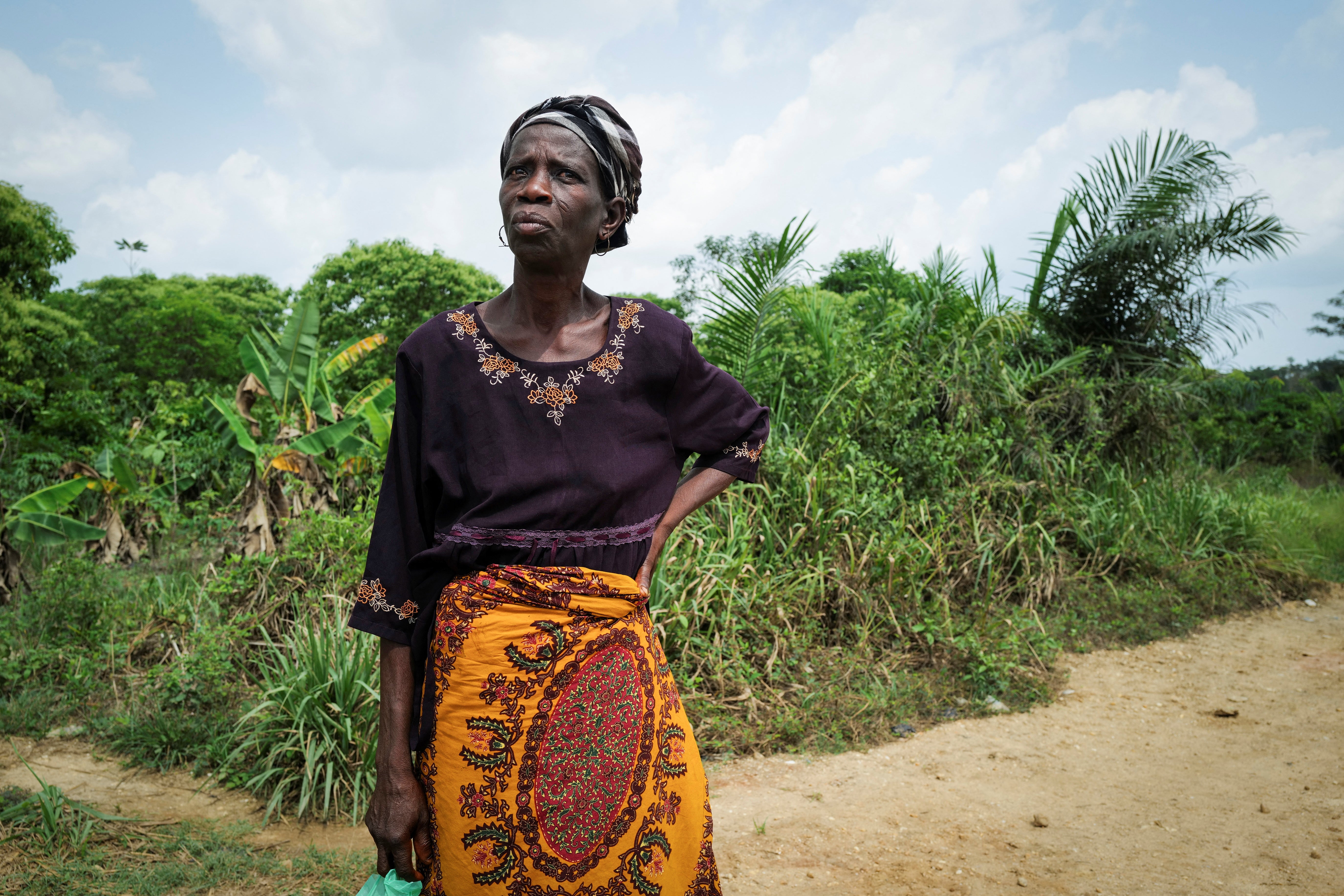 Felicia Gasikah, a cocoa farmer, stands at the edge of her land, which is threatened by gold mining