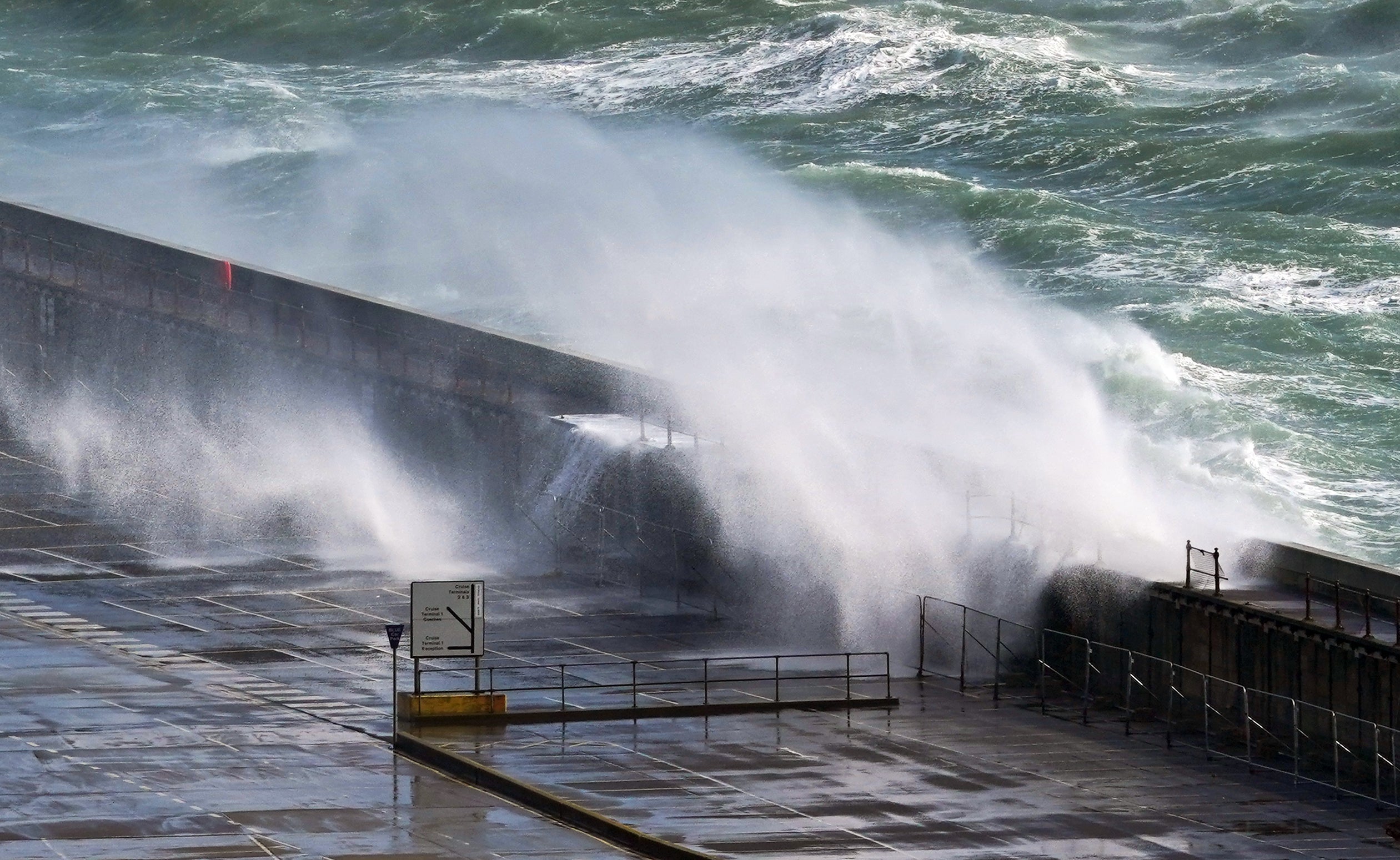 Waves crash over the harbour wall in Dover, Kent