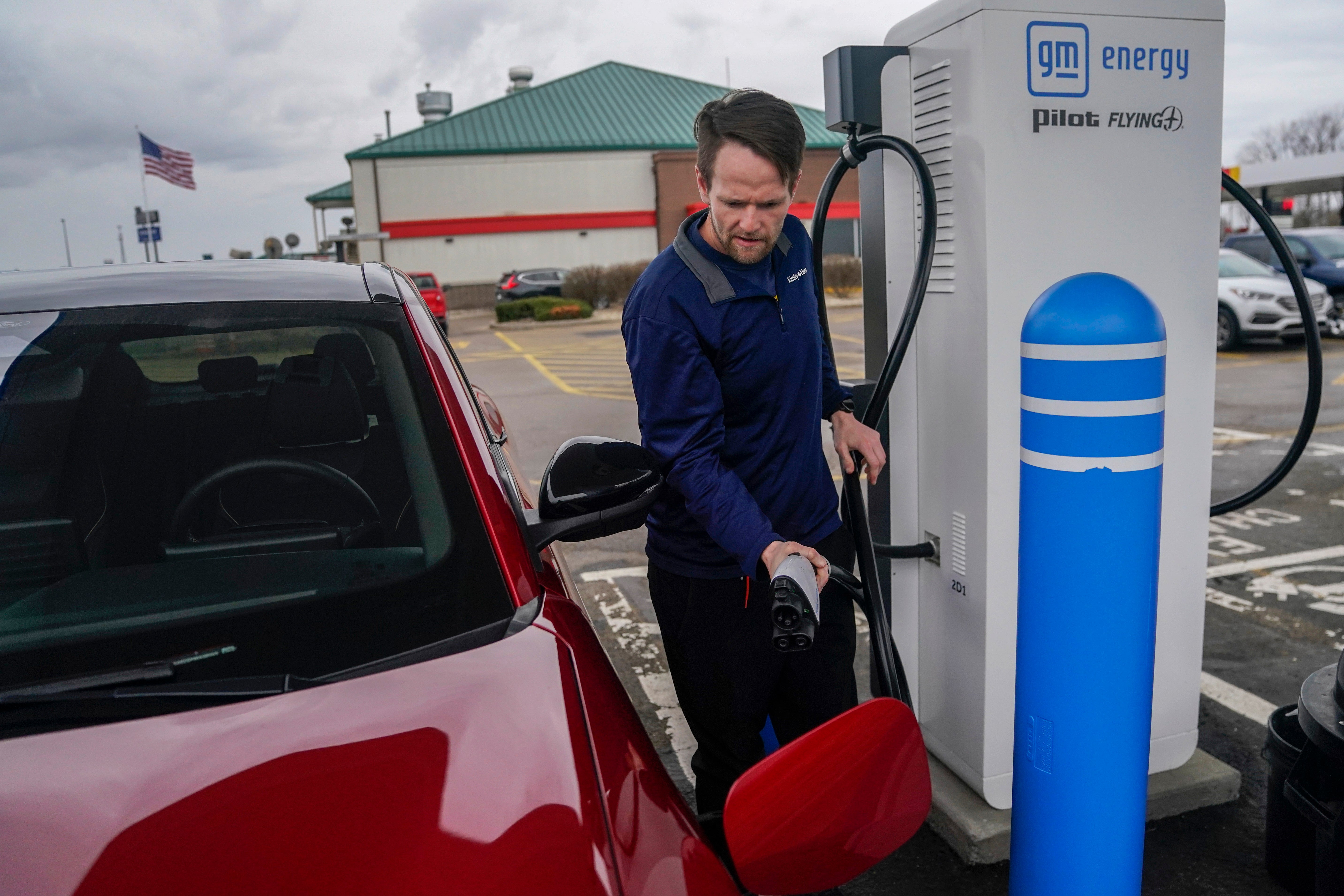 Liam Sawyer charges his Ford Mustang Mach-E, earlier this month at an electric vehicle charging station in London, Ohio. The charging ports are key to the US transition to EVs but the US government’s rollout has been slow