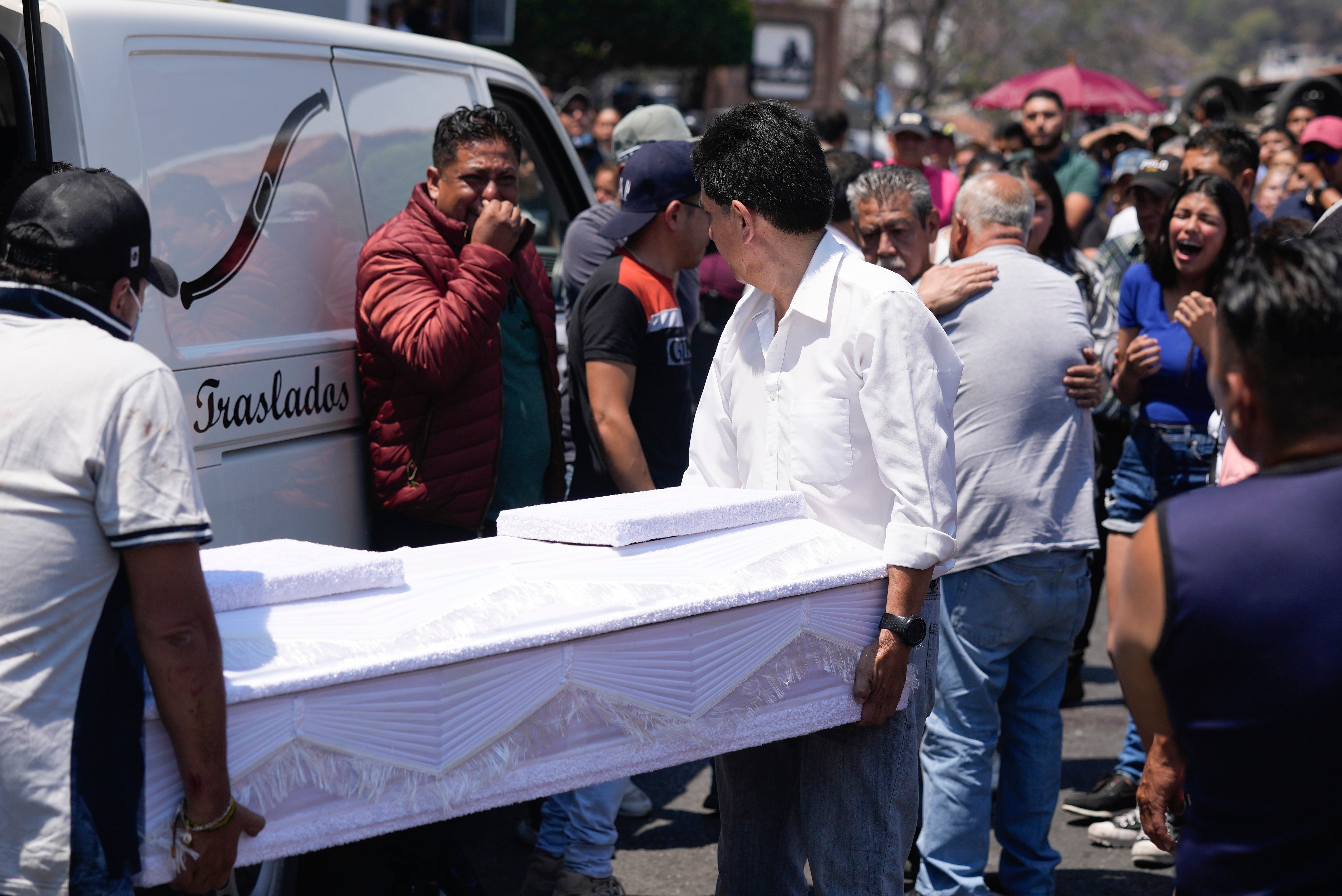 Funeral workers carry the coffin that contain the remains of an 8-year-old girl, in Taxco, Mexico