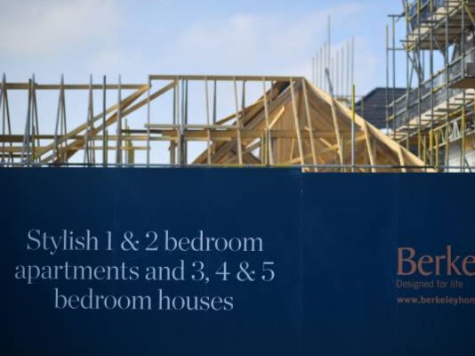 Builders work on a residential construction site in Paddock Wood