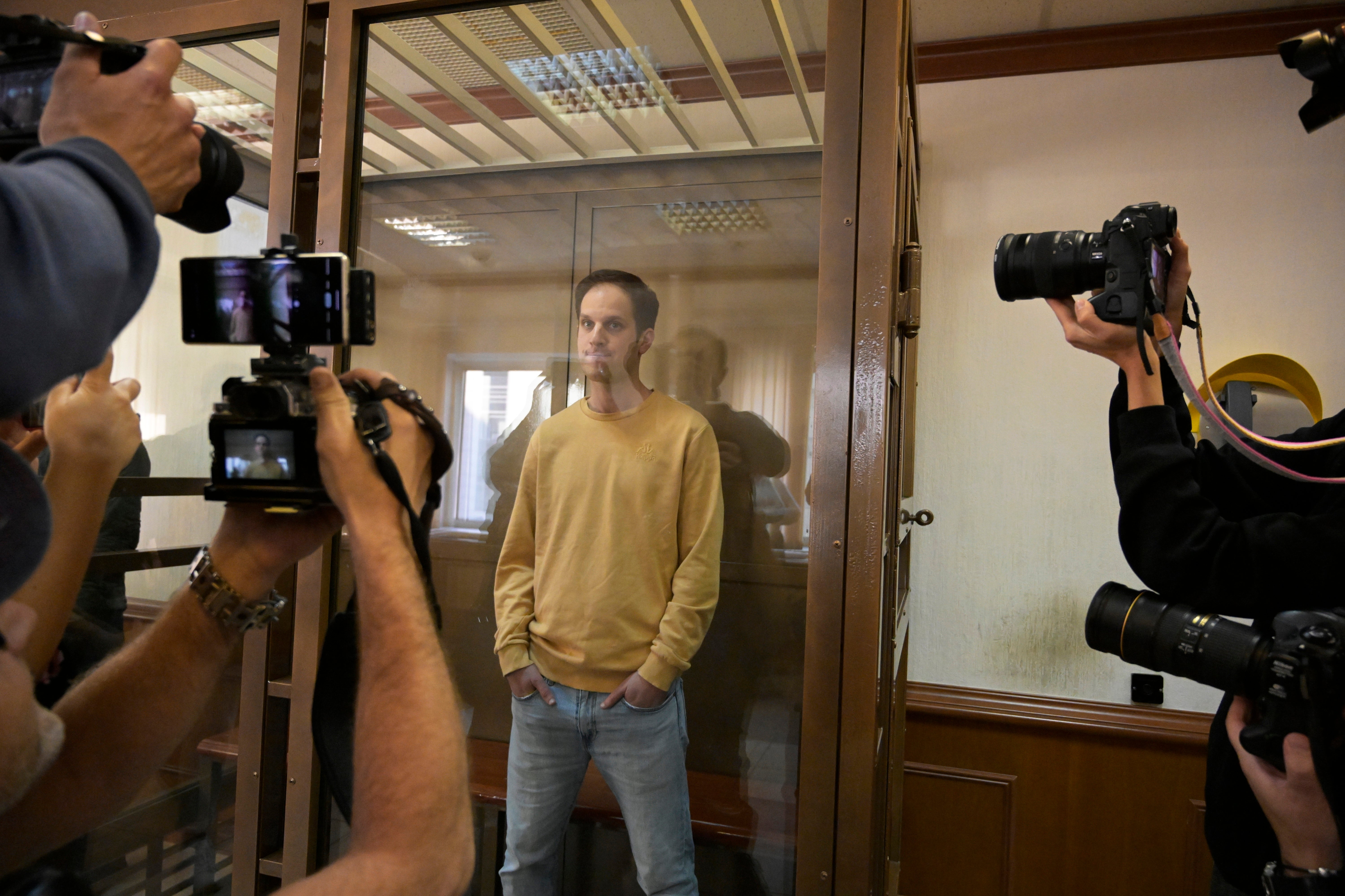Evan Gershkovich stands in a glass cage in a Moscow courtroom in September 2023