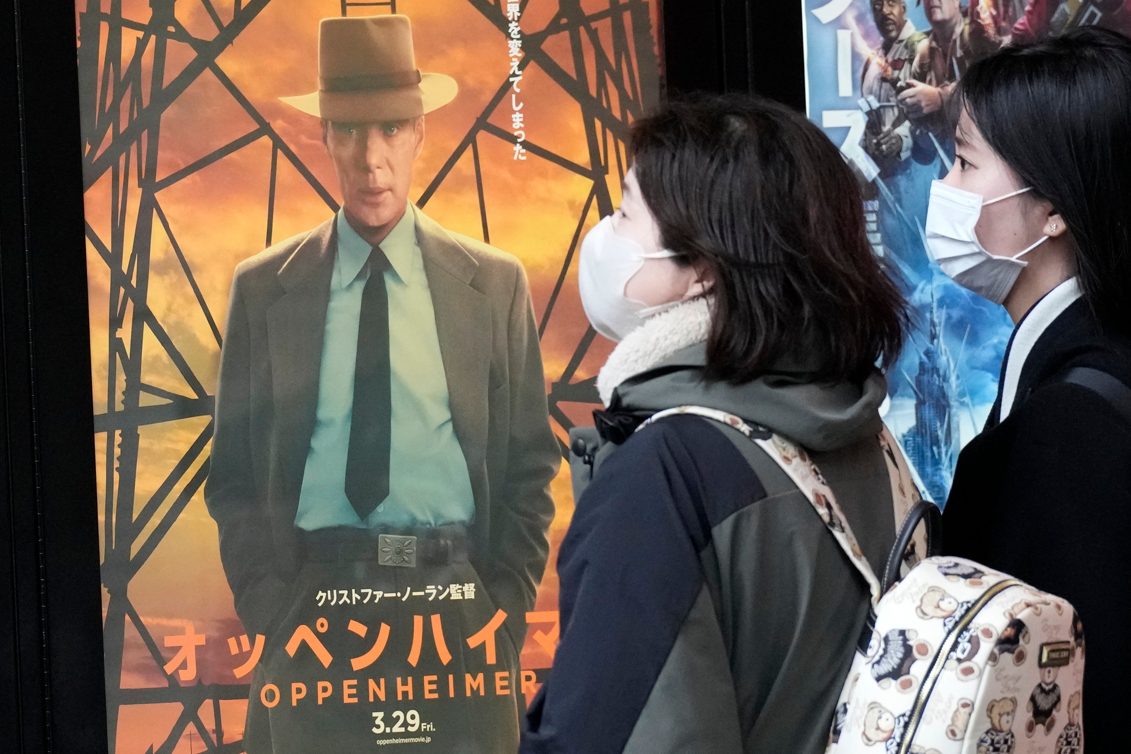 People walk by a poster to promote the multiple Oscar-winning movie in Tokyo on 29 March