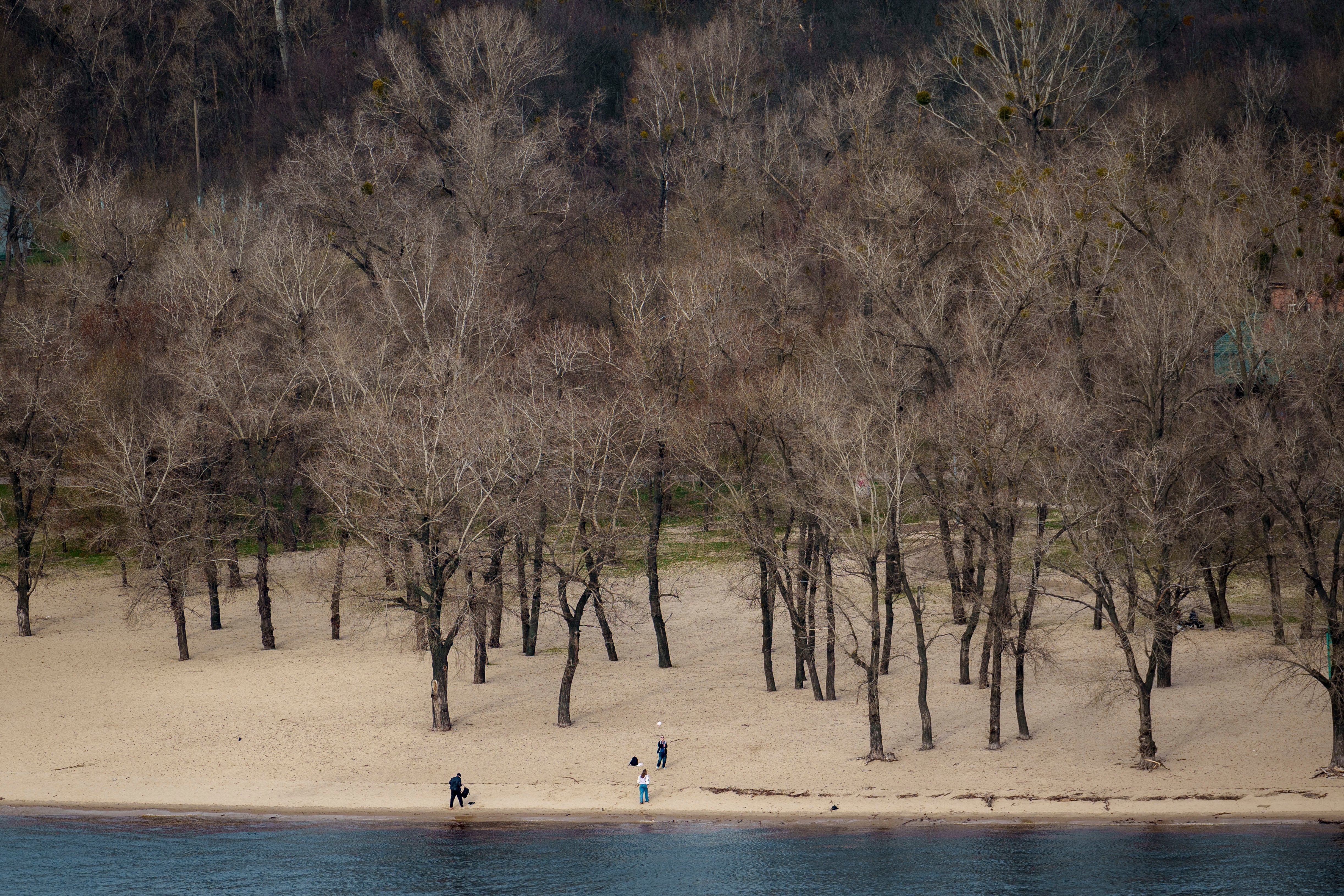 People play on the bank of the Dniepr River, in Kyiv, Ukraine