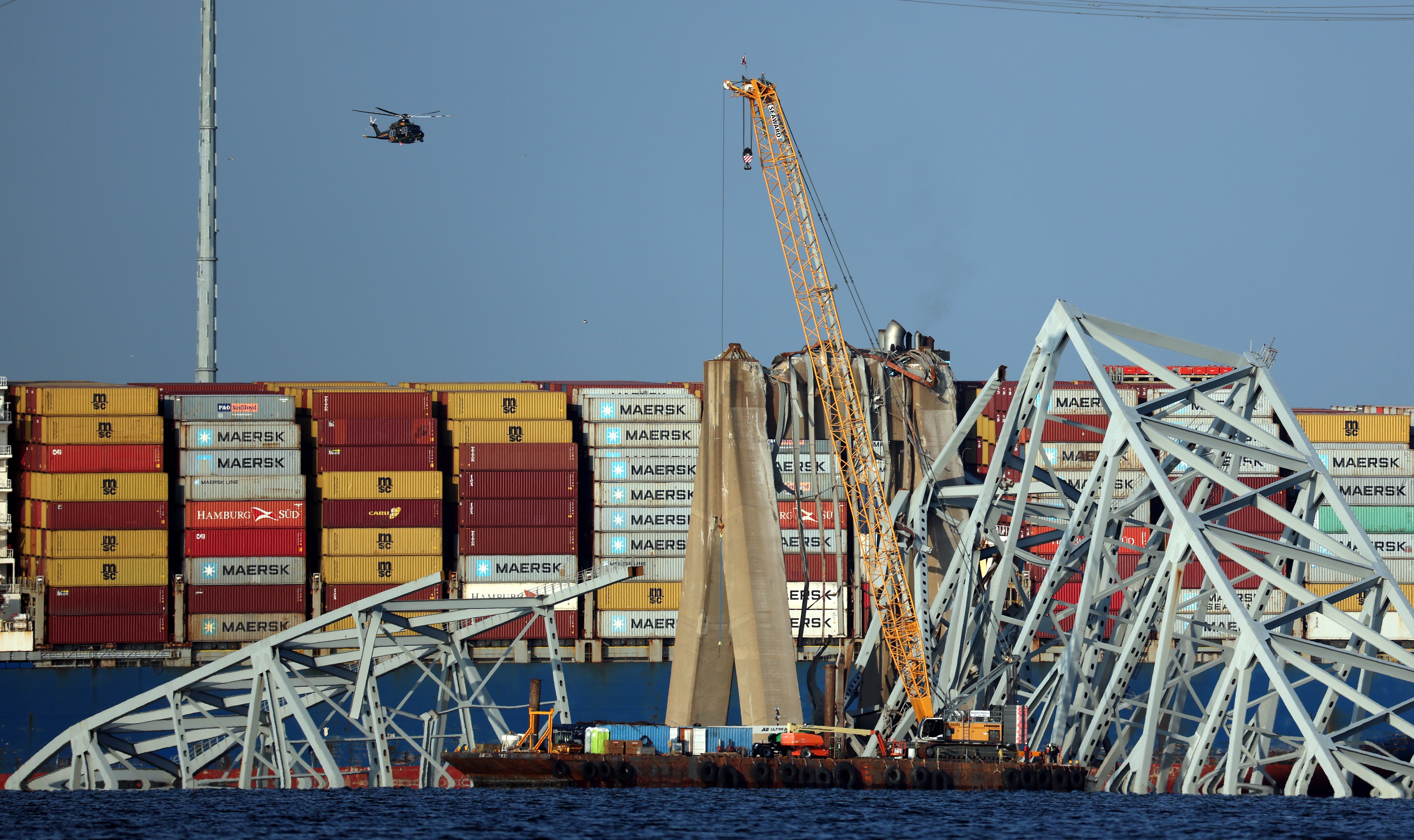 A crane works on clearing debris from the Francis Scott Key Bridge