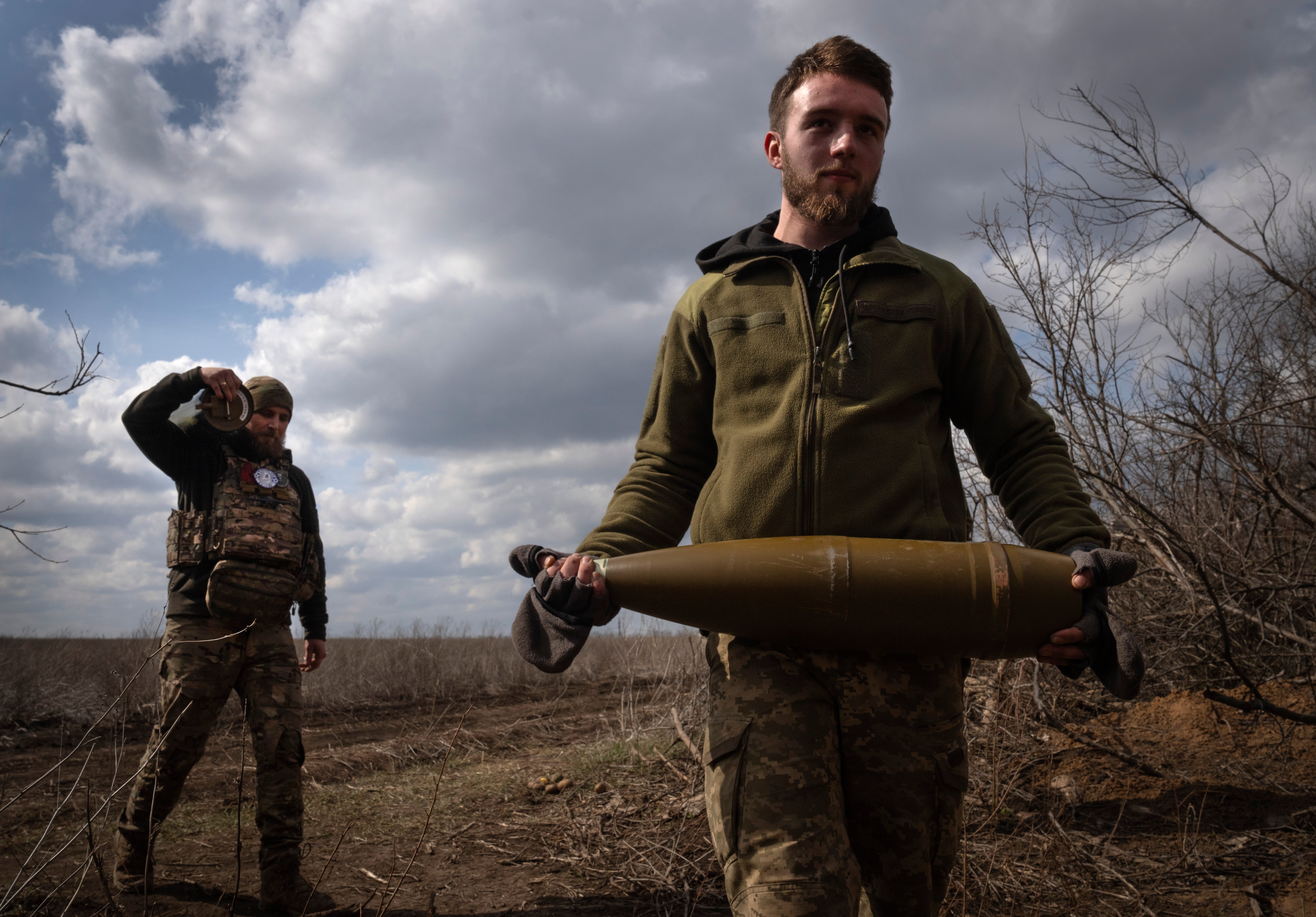 Ukrainian soldiers carry shells to fire towards Russian positions at the frontline, near Bakhmut, Donetsk region
