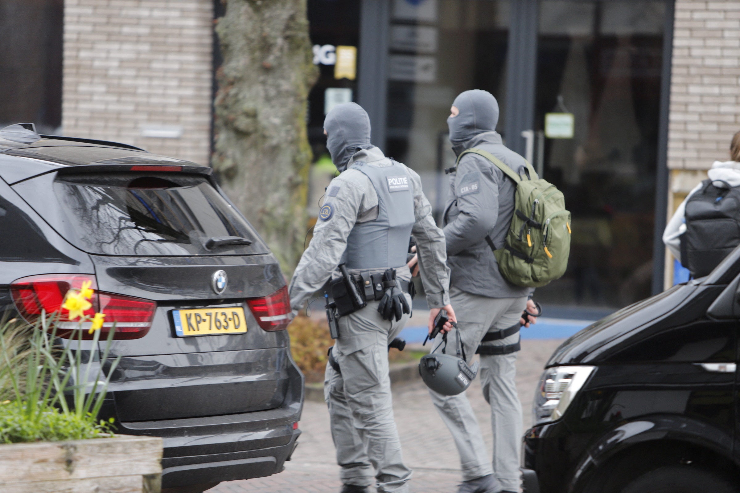 Armed police officers walk near the Cafe Petticoat, where several people were being held hostage