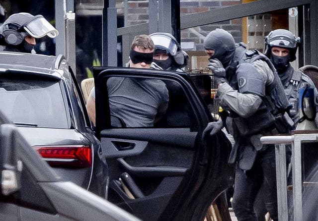 <p>A man (C) is detained by the Special Intervention Service (DSI) of the Dutch National Police Corps outside a cafe in the center of Ede</p>