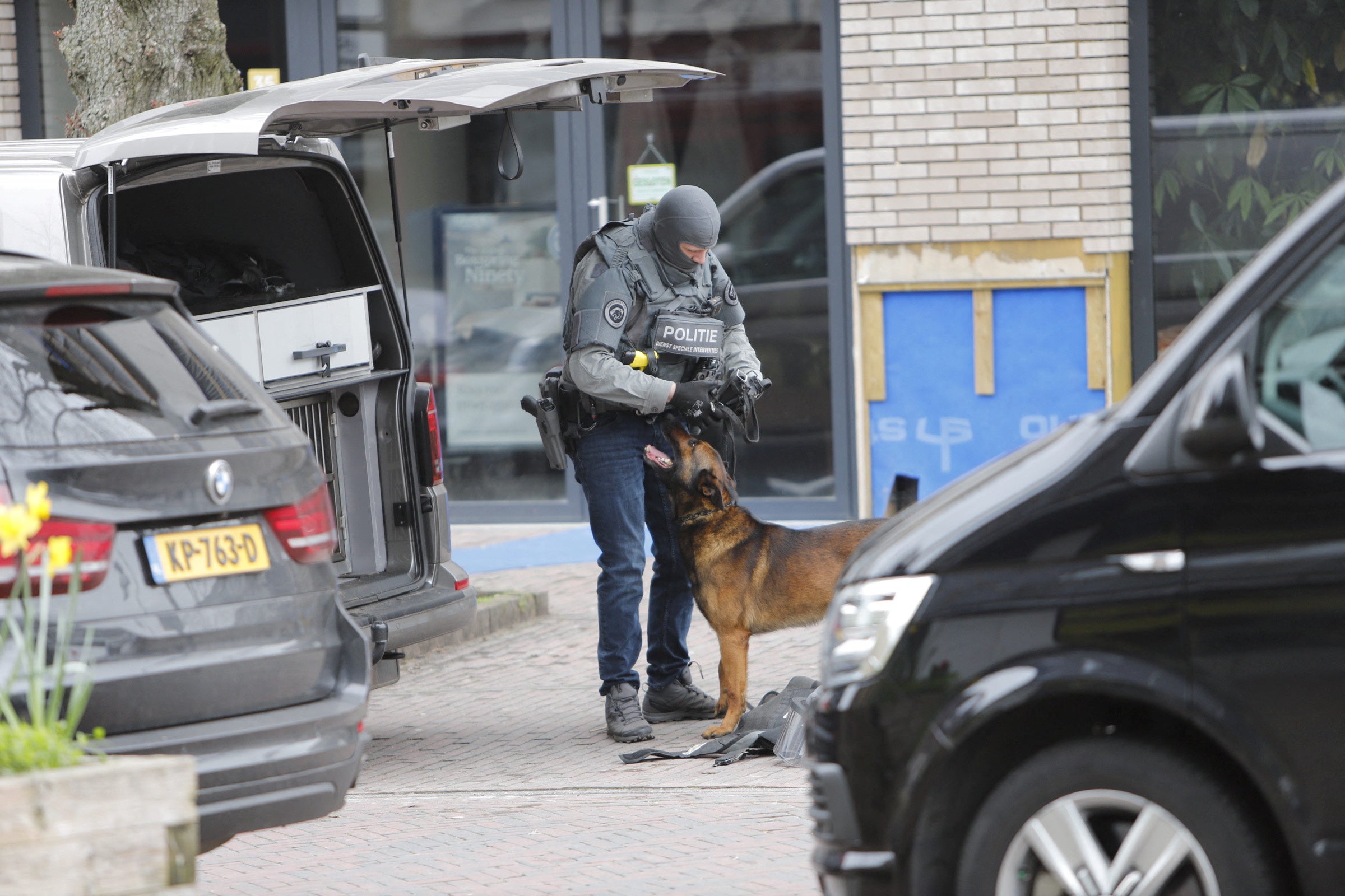An armoured police officer handles a police dog near the Cafe Petticoat