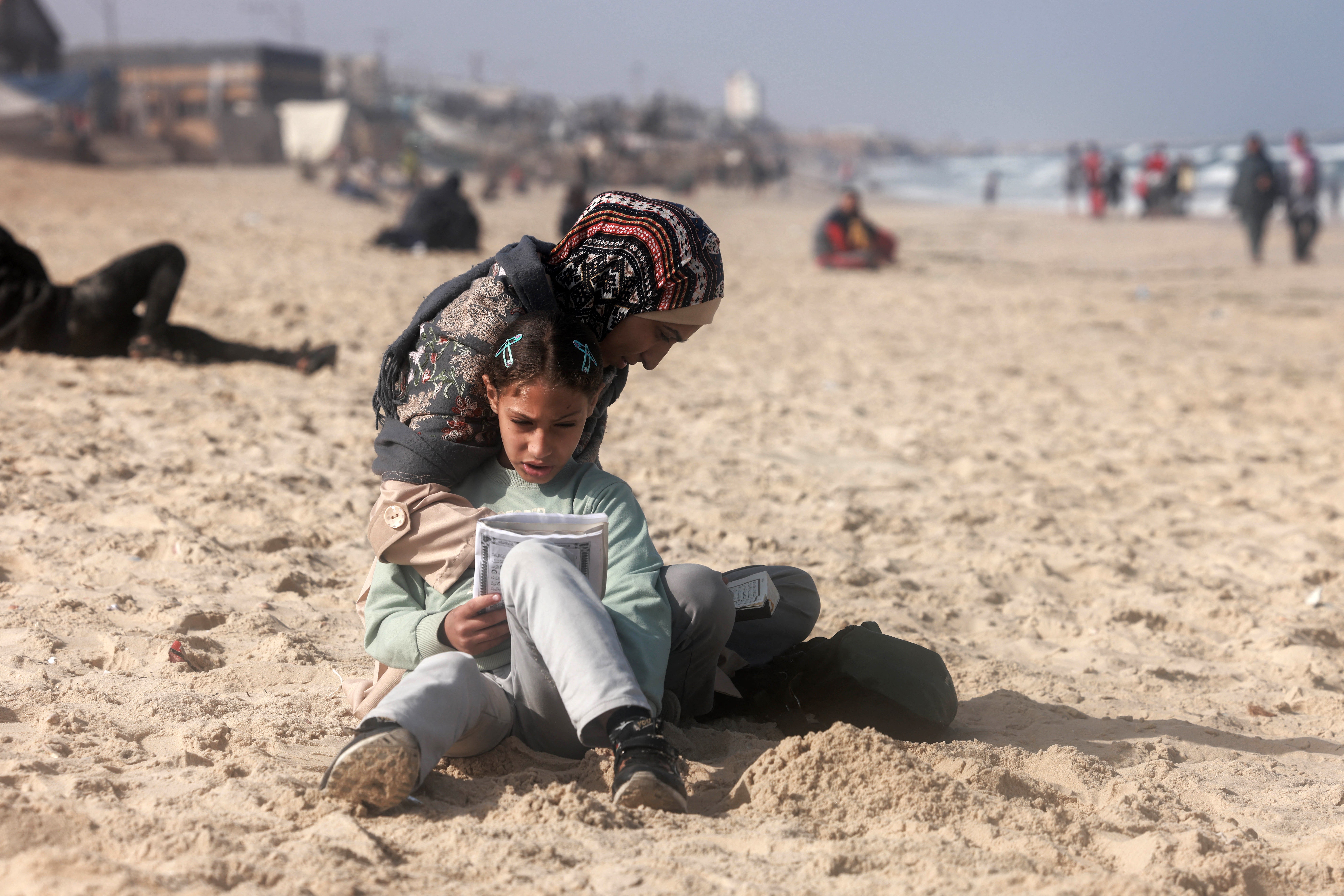 A Palestinian woman and a girl on a beach near a makeshift camp for displaced people in Rafah, southern Gaza, on Saturday