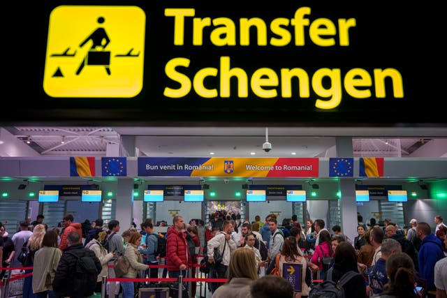 <p>Passengers arriving at the Henri Coanda International Airport pass under a Schengen Information sign, in Otopeni, near Bucharest, Romania </p>