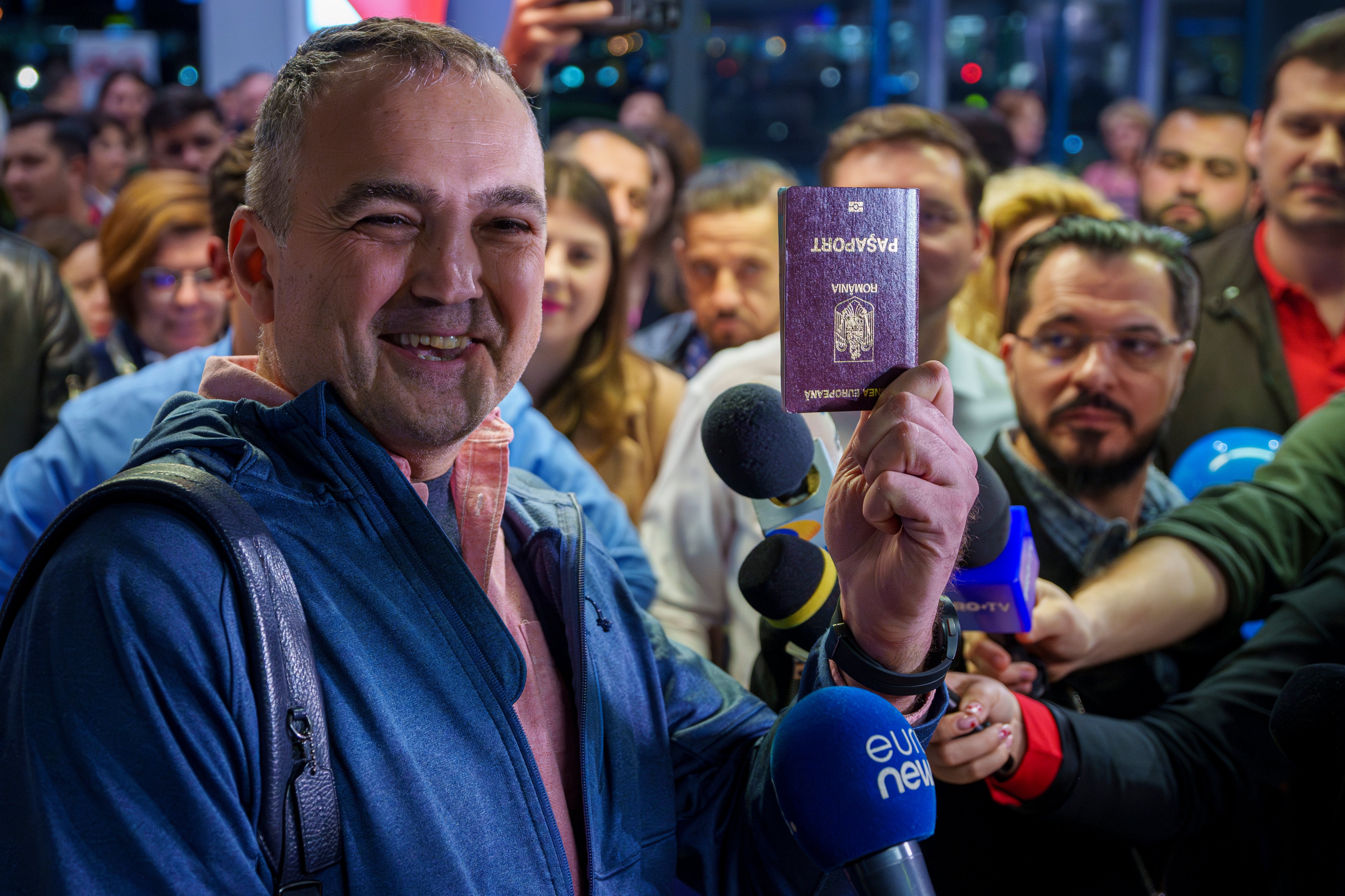 A passenger that arrived with a flight from Vienna shows his passport after being one of the first people to take advantage