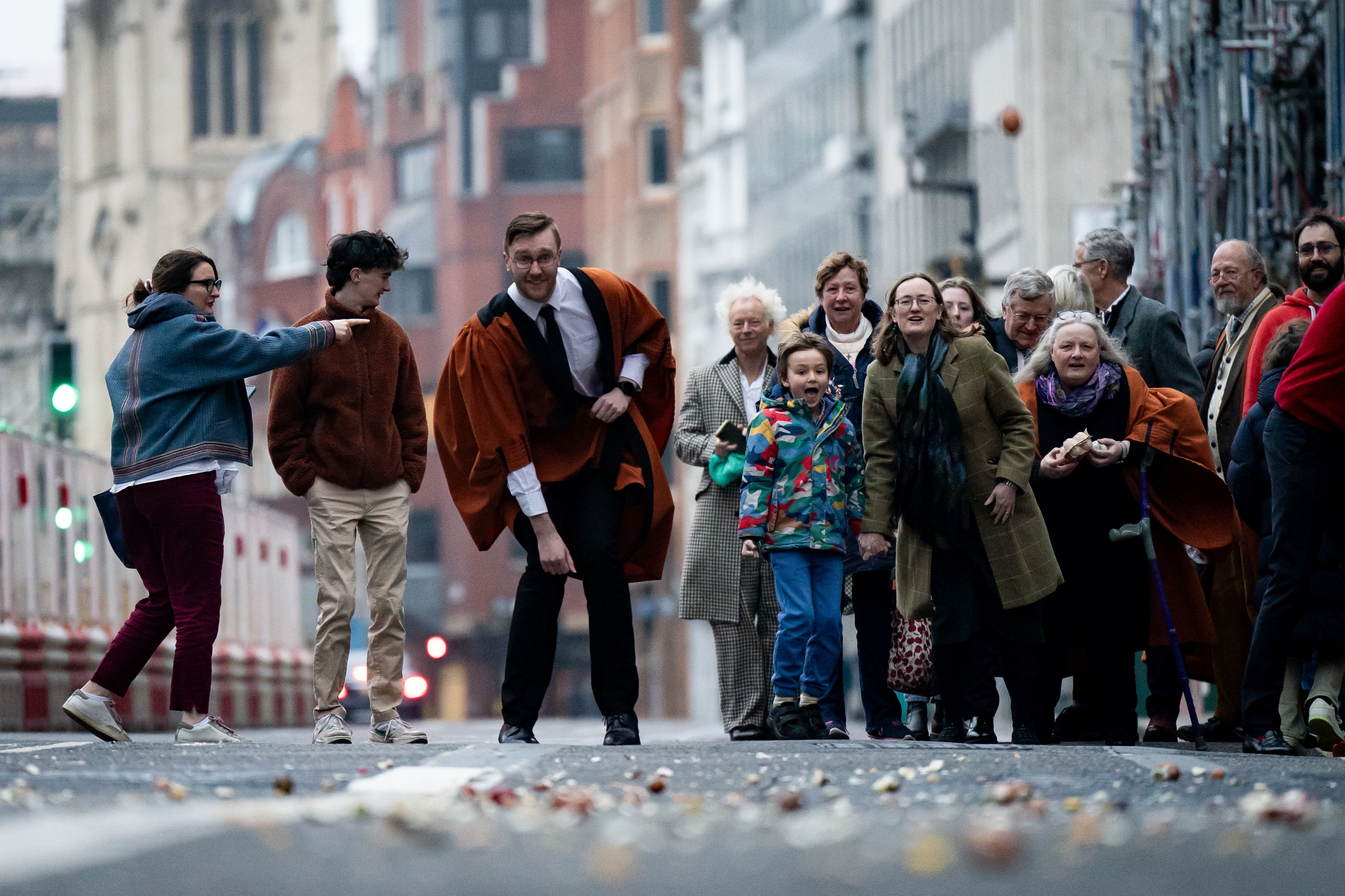 People take part in rolling hard boiled eggs on Fleet Street outside St Bride’s Church, in London (Aaron Chown/PA)