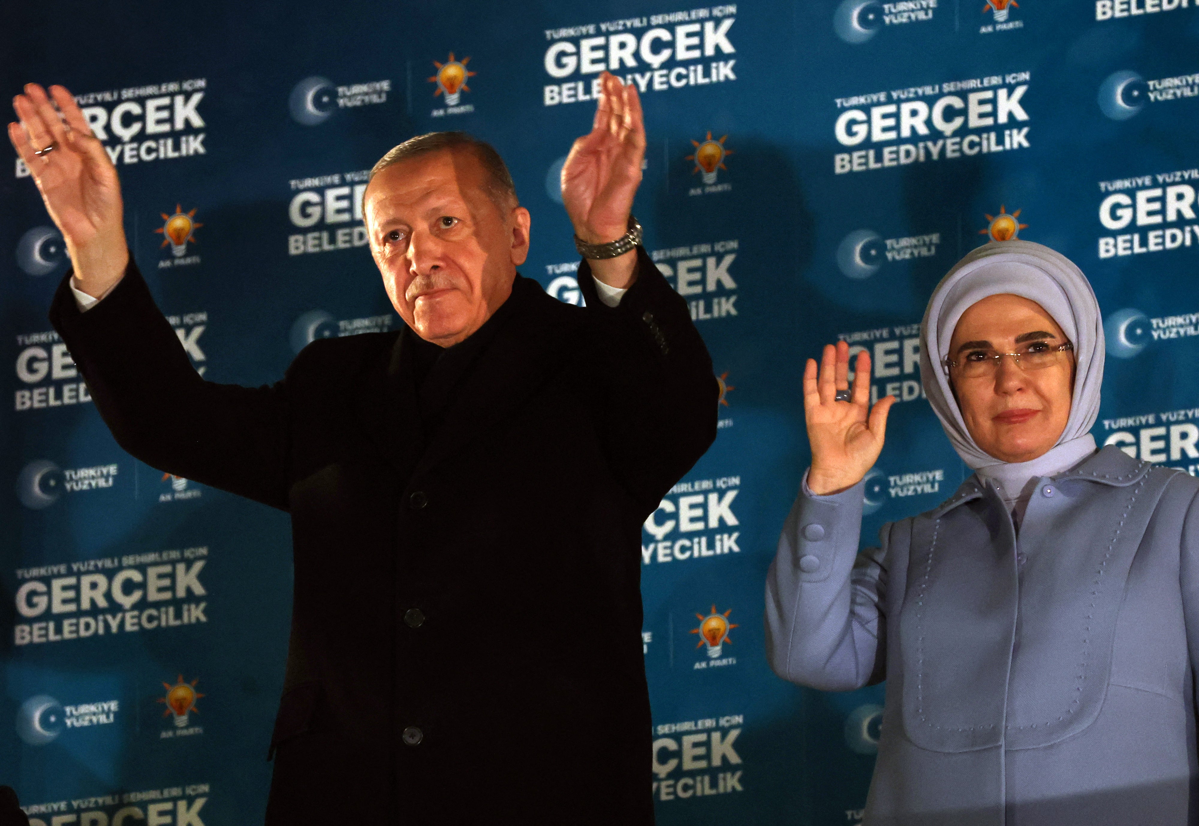 Turkish President Recep Tayyip Erdogan and his wife Emine Erdogan wave to their supporters in Ankara