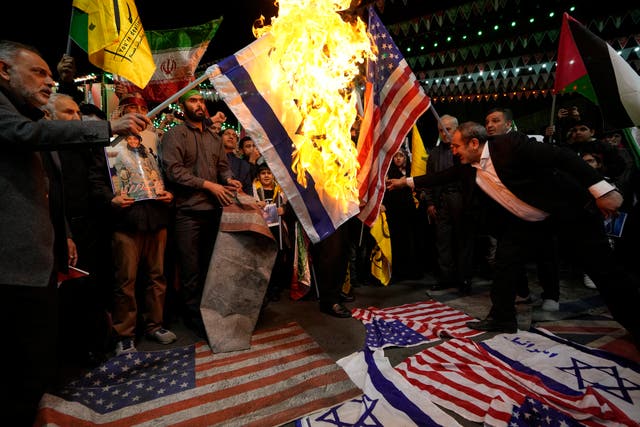 <p>Iranian protesters burn US and Israeli flags after an airstrike on Tehran’s consulate in Syria</p>
