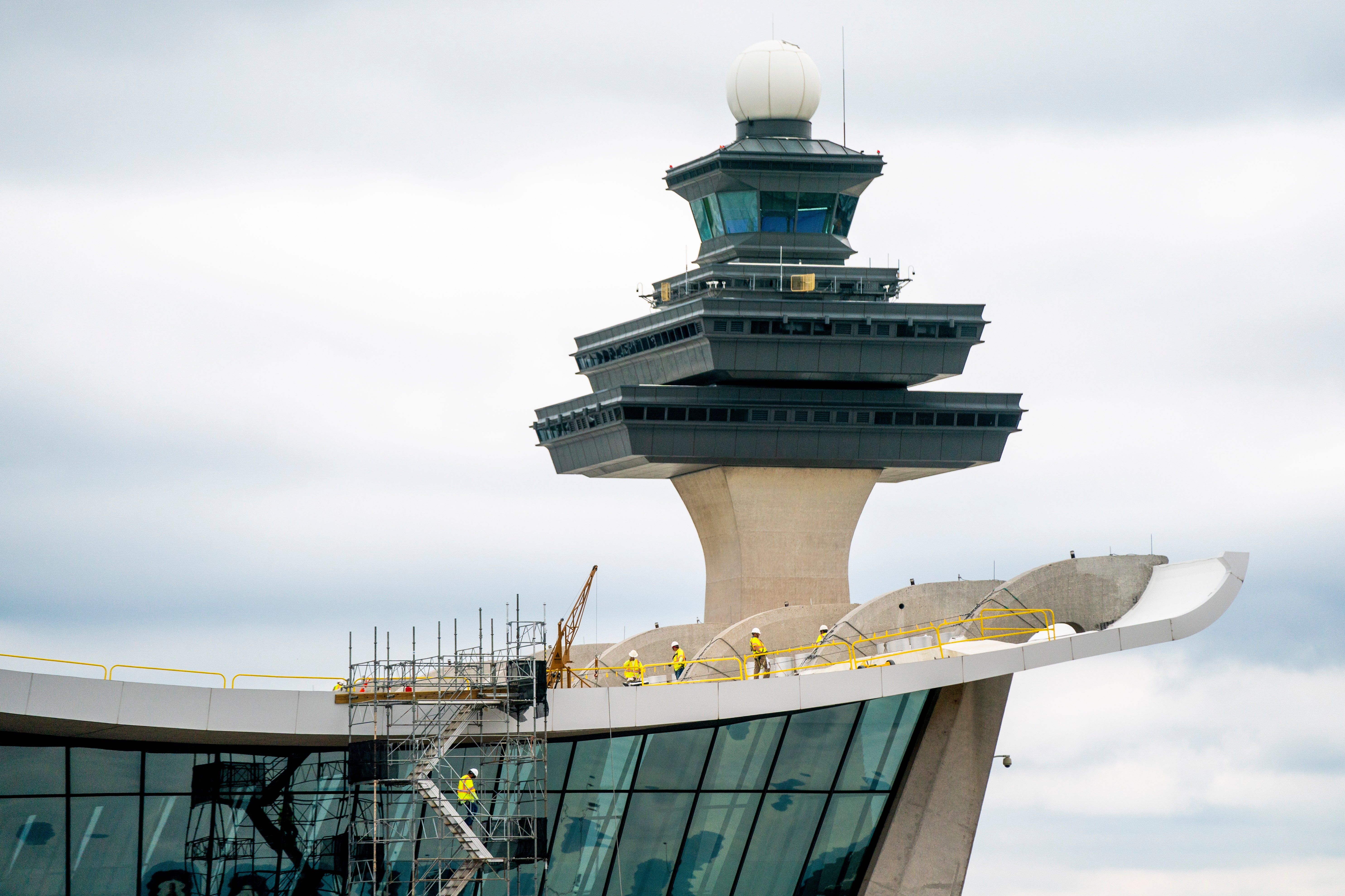 An airport work crew conducts repairs to the roof of the main terminal at Dulles International Airport