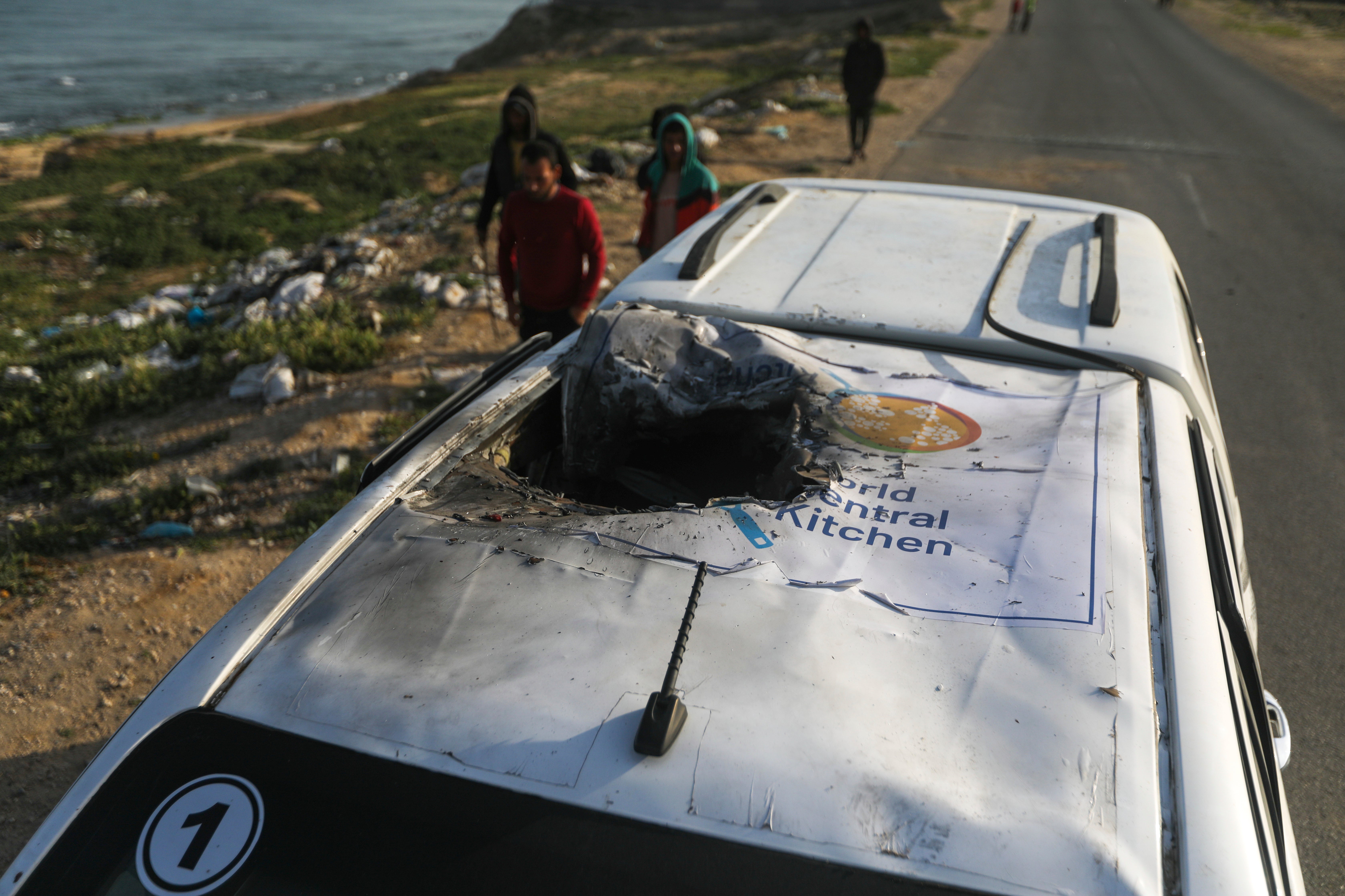 Palestinians inspect a vehicle with the logo of the World Central Kitchen wrecked by an Israeli airstrike in Deir al Balah, Gaza