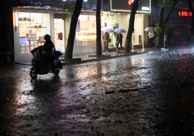 <p>Residents pass through rain storm in Nanchang in eastern China’s Jiangxi province Tuesday, 2 April 2024</p>