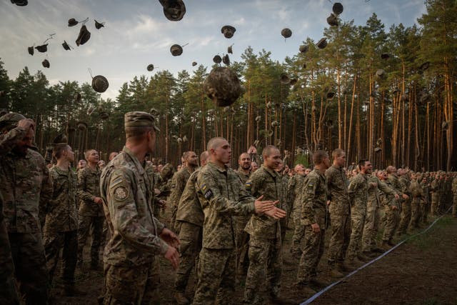 <p>Newly recruited soldiers shout slogans as they celebrate the end of their training at a military base close to Kyiv, Ukraine</p>