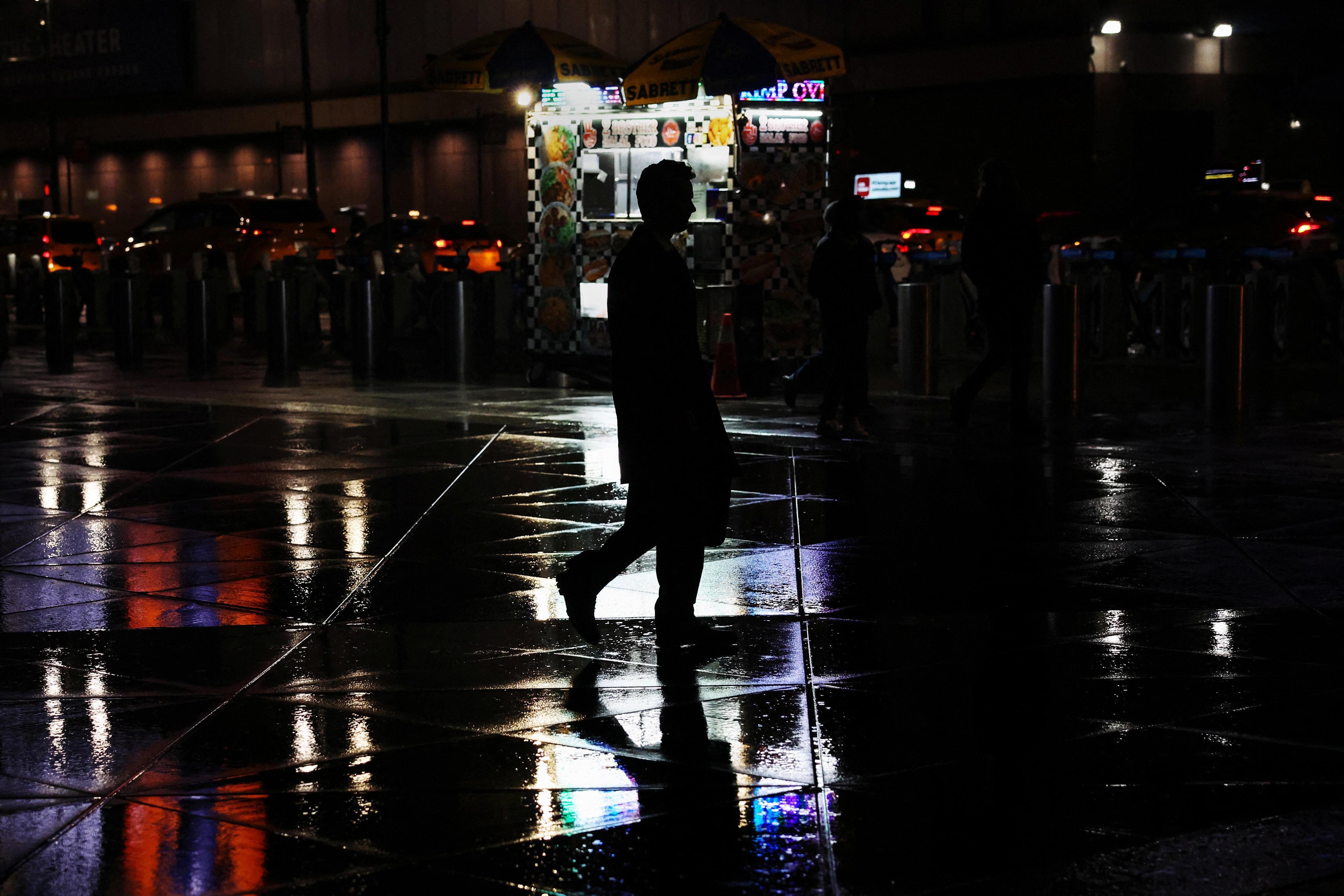 A man walks through heavy rain near Pennsylvania Station in New York City on April 2, 2024