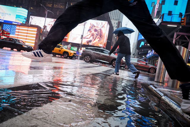 <p>People walk through wind and rain during a nor'easter storm in Times Square in New York City on April 3, 2024</p>