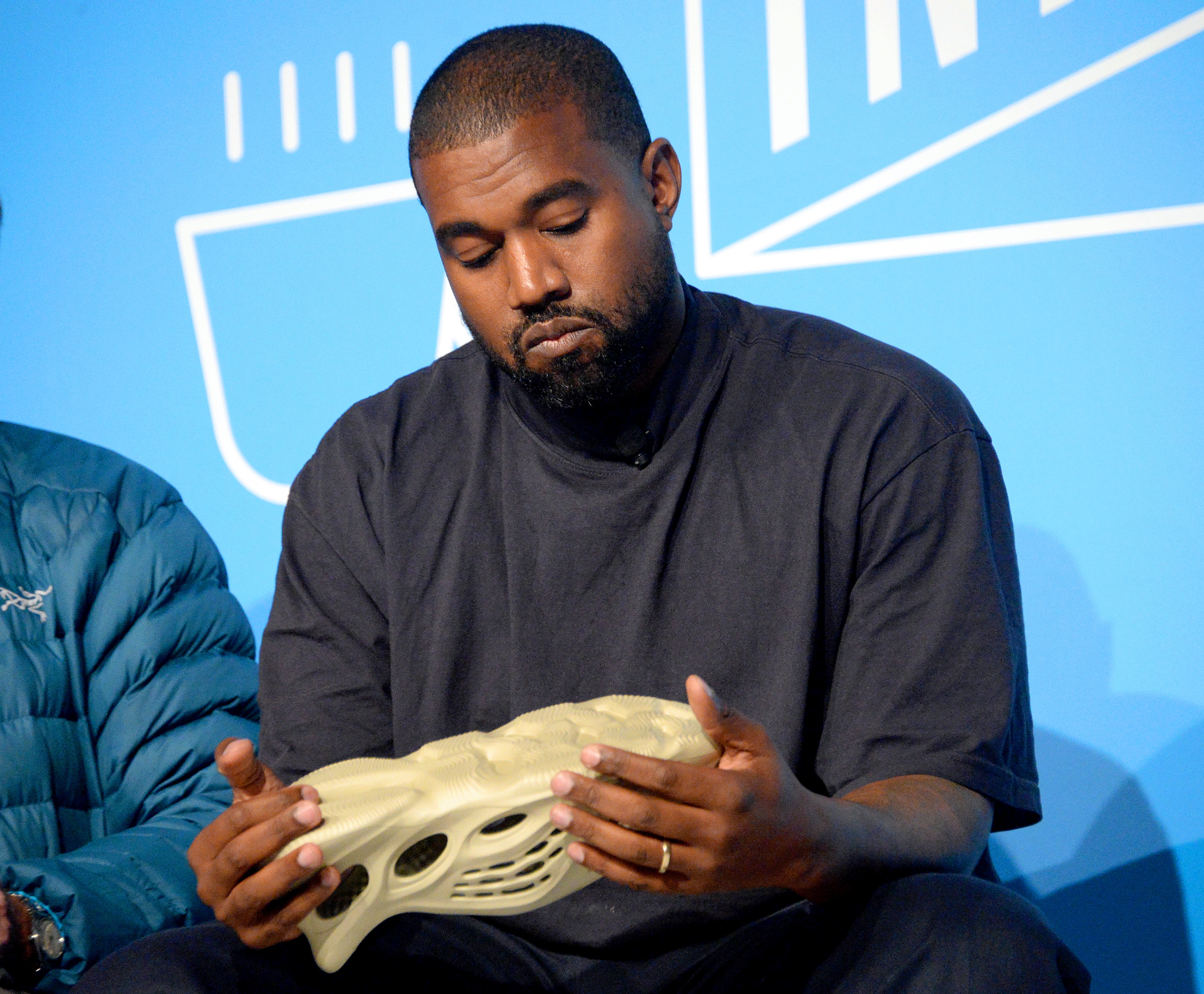 Kanye West holding a Yeezy shoe in 2019