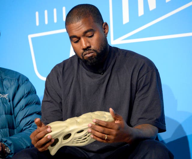 <p>Kanye West holding a Yeezy shoe in 2019</p>
