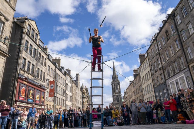 <p>Street performers entertain the crowds on Edinburgh’s Royal Mile at Edinburgh Festival Fringe (Jane Barlow/PA)</p>