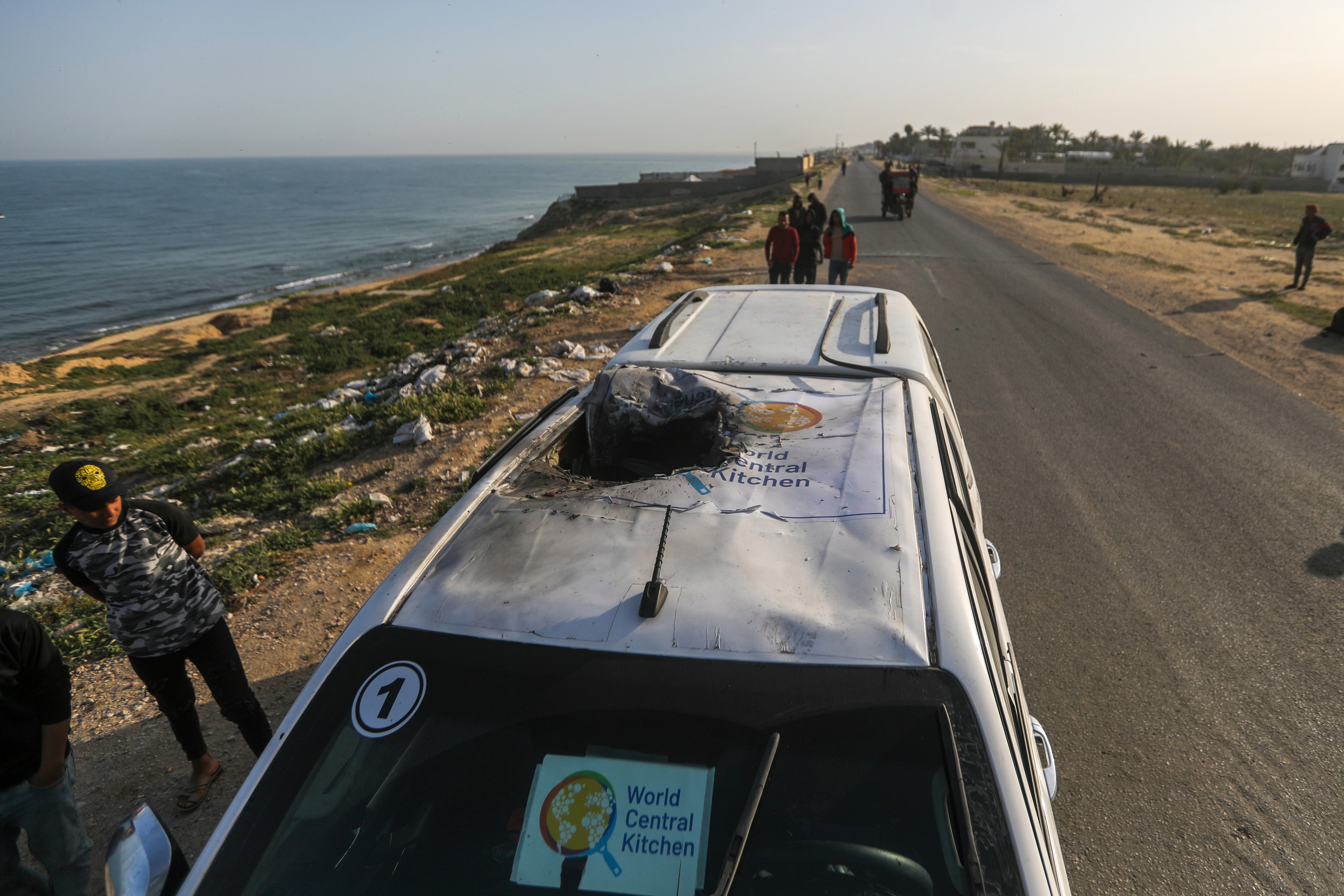 Palestinians inspect a vehicle with the logo of the World Central Kitchen wrecked by an Israeli airstrike in Deir al Balah, Gaza Strip, Tuesday, 2 April 2024