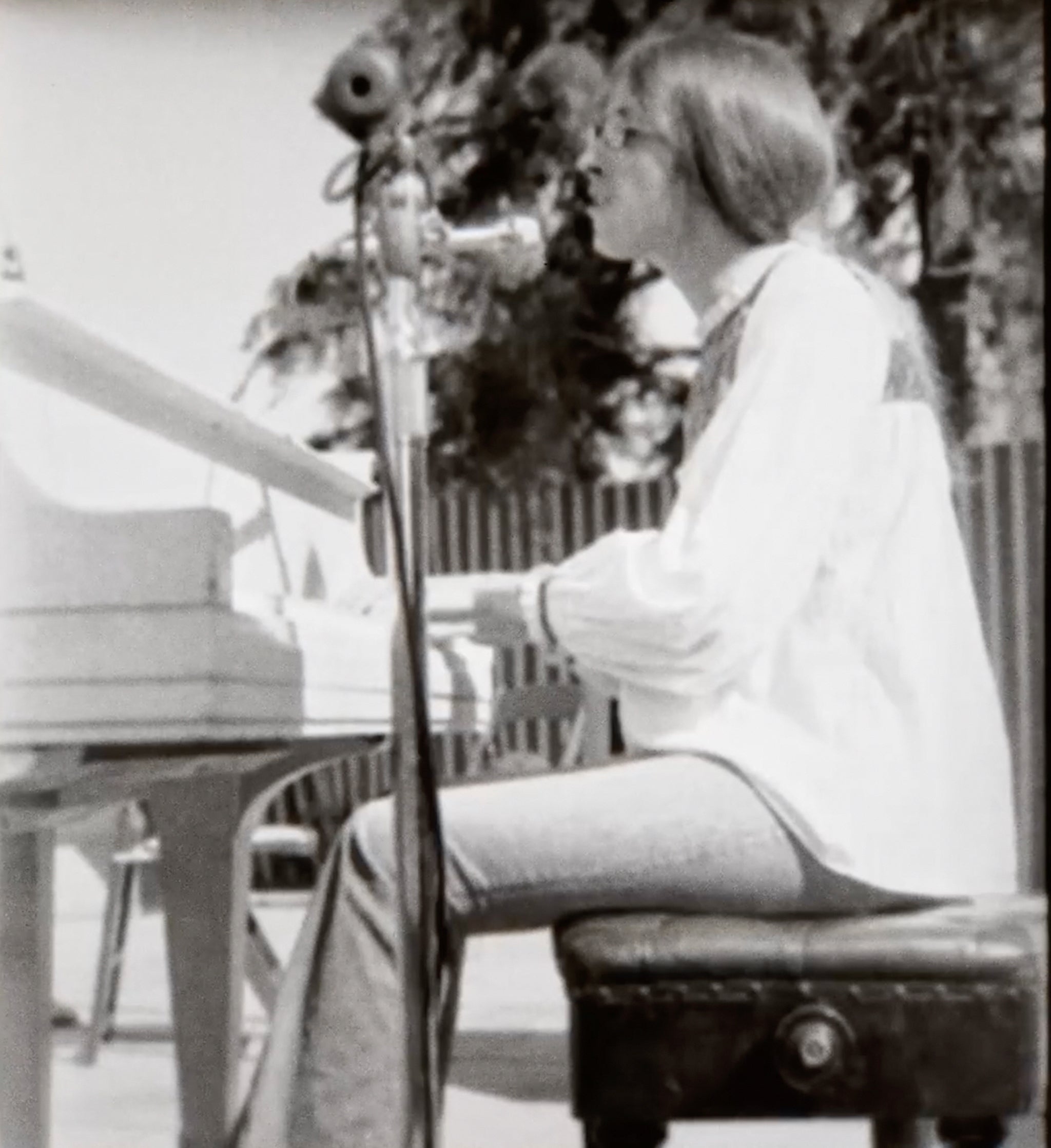 Judee Sill playing piano outdoors