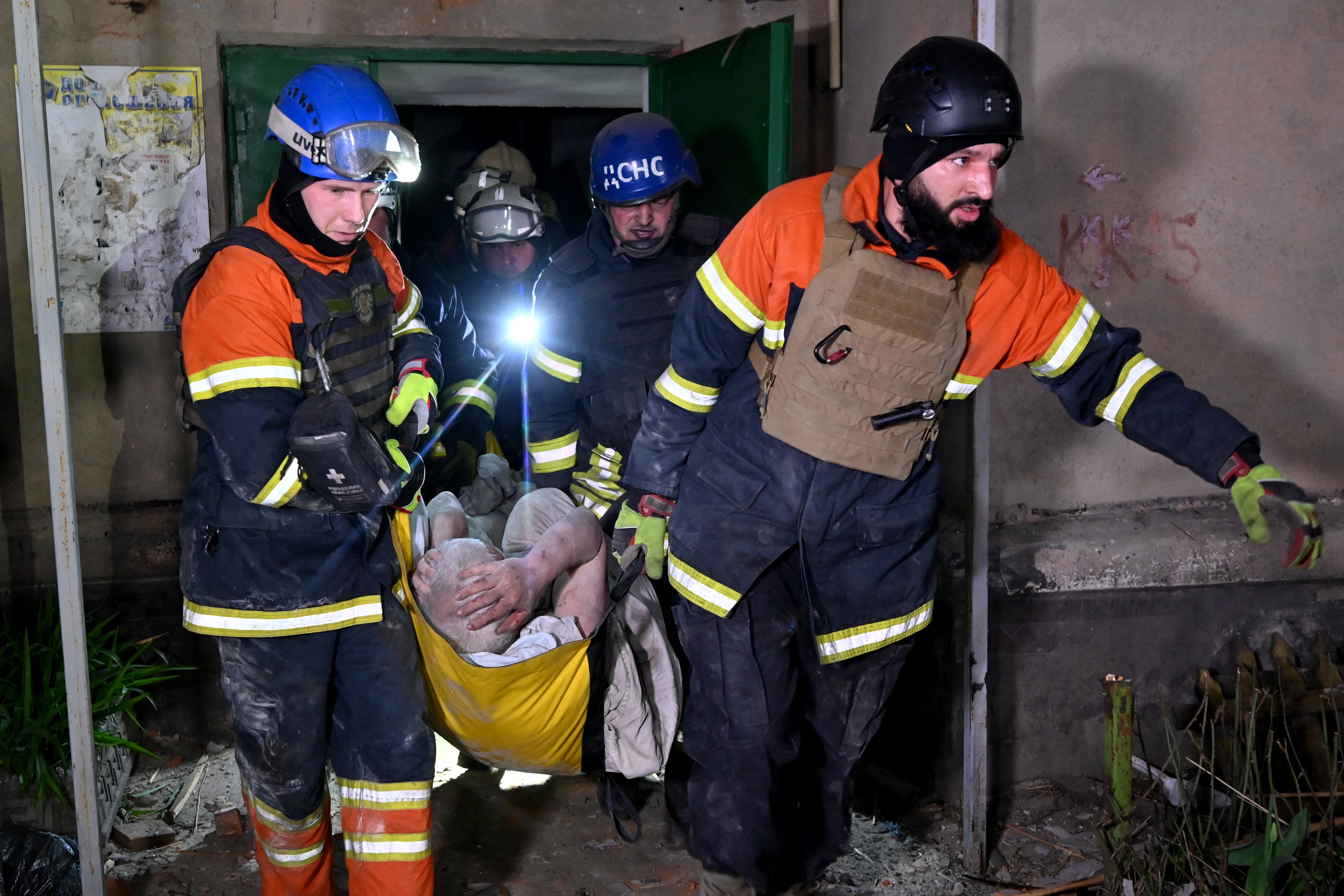 Rescuers carry an injured resident following a missile attack in Kharkiv on Thursday