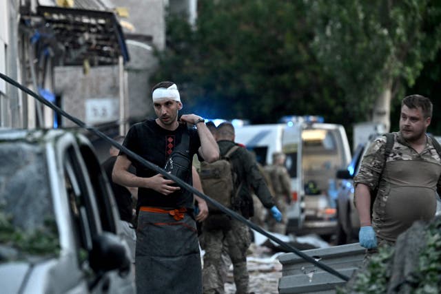 <p>A wounded man walks near the rubble of the pizzeria in Kramatorsk that was struck by a Russian missile in June last year </p>