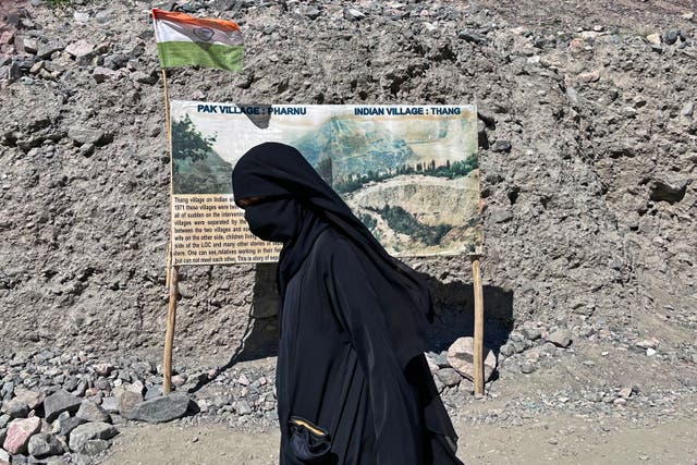 <p>A woman walks near the Line of Control, the border between India and Pakistan in the restive Kashmir region </p>