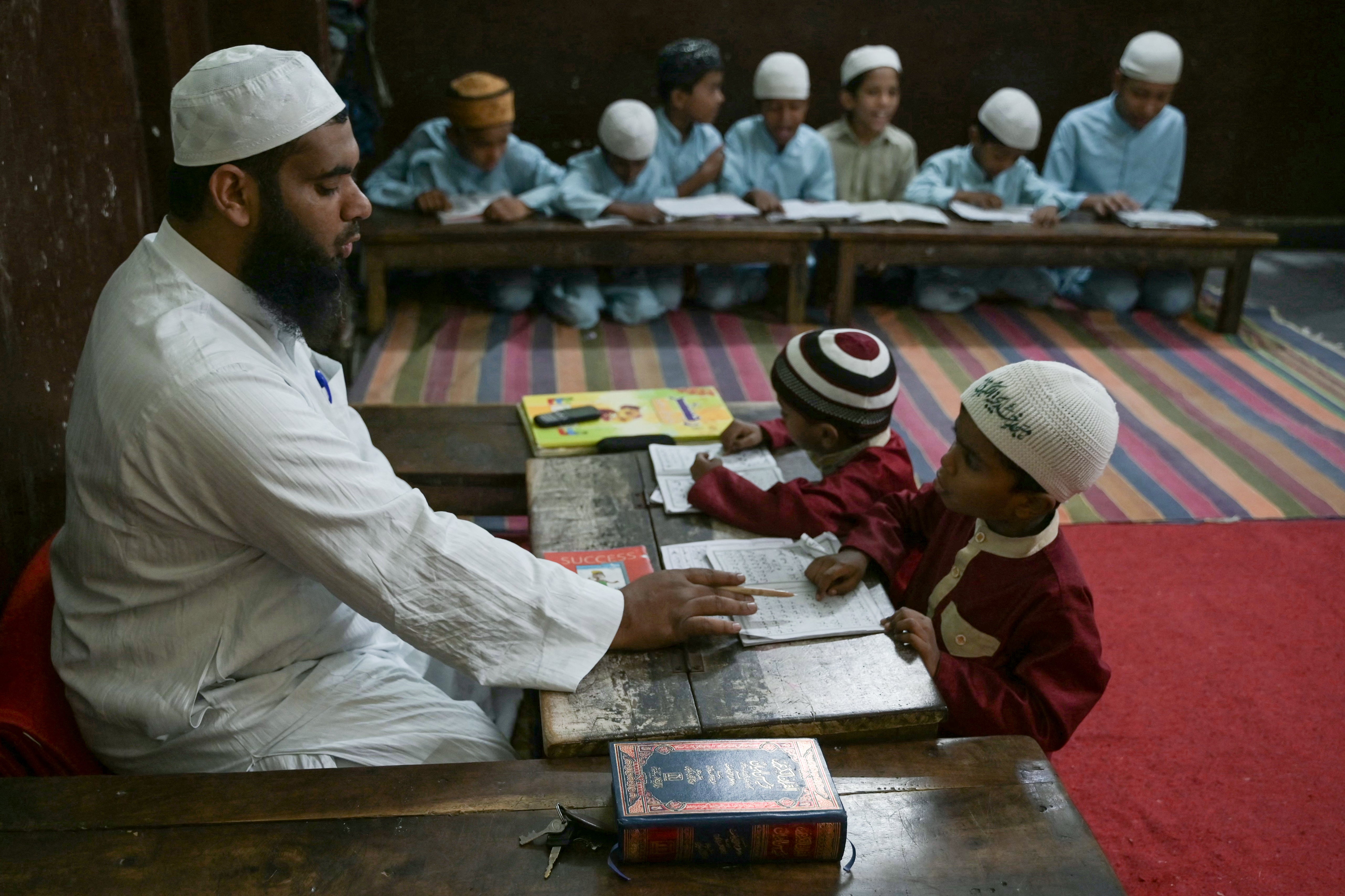 A teacher watches as students recite the Holy Quran in a classroom during the Islamic holy month of Ramadan