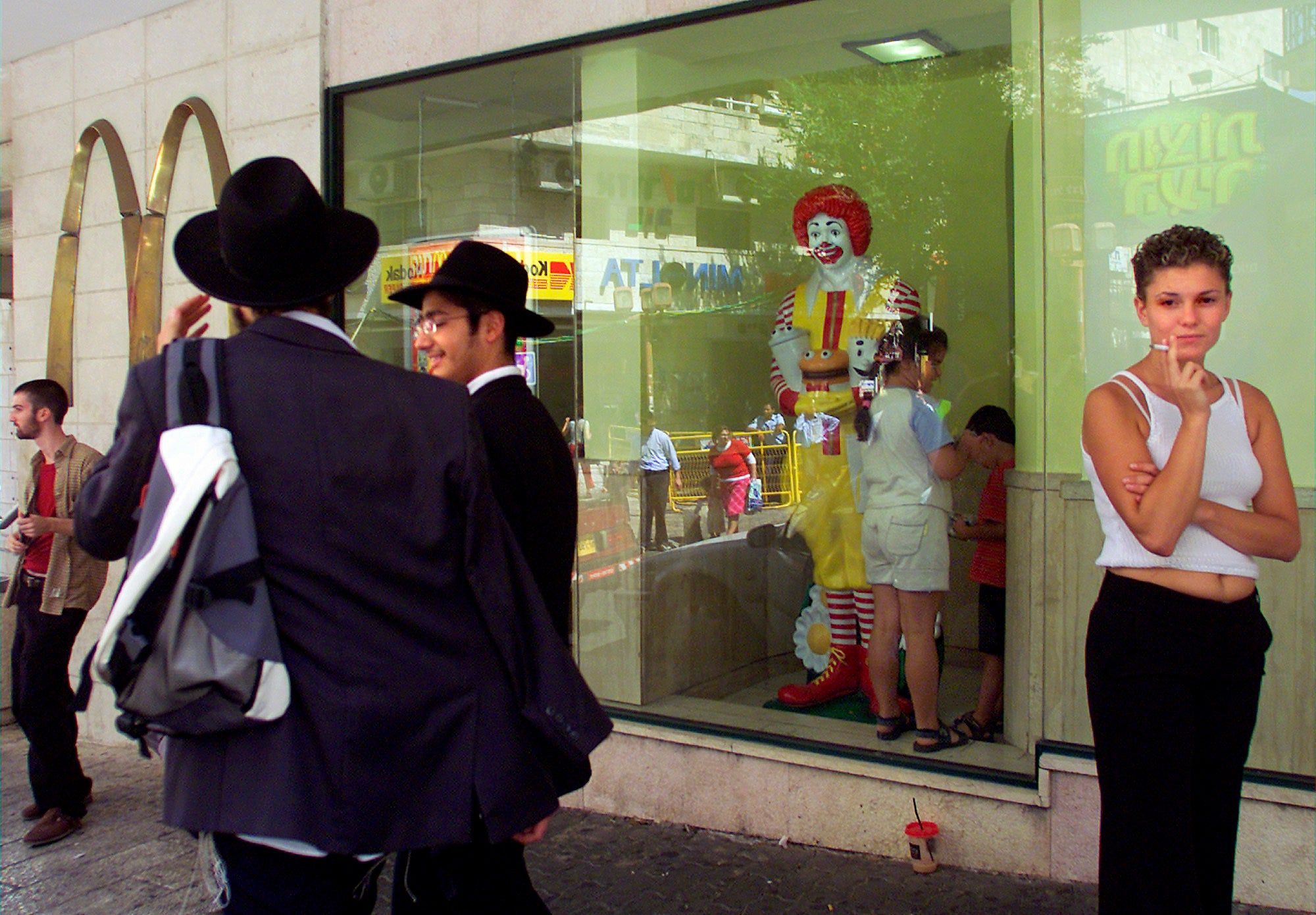 Residents of Jerusalem mingle inside and outside of the city's downtown McDonald's fast food restaurant Friday August. 16, 2002. McDonald’s is buying its restaurants in Israel from a longtime franchisee, hoping to reset sales that have slumped due to boycotts in the region