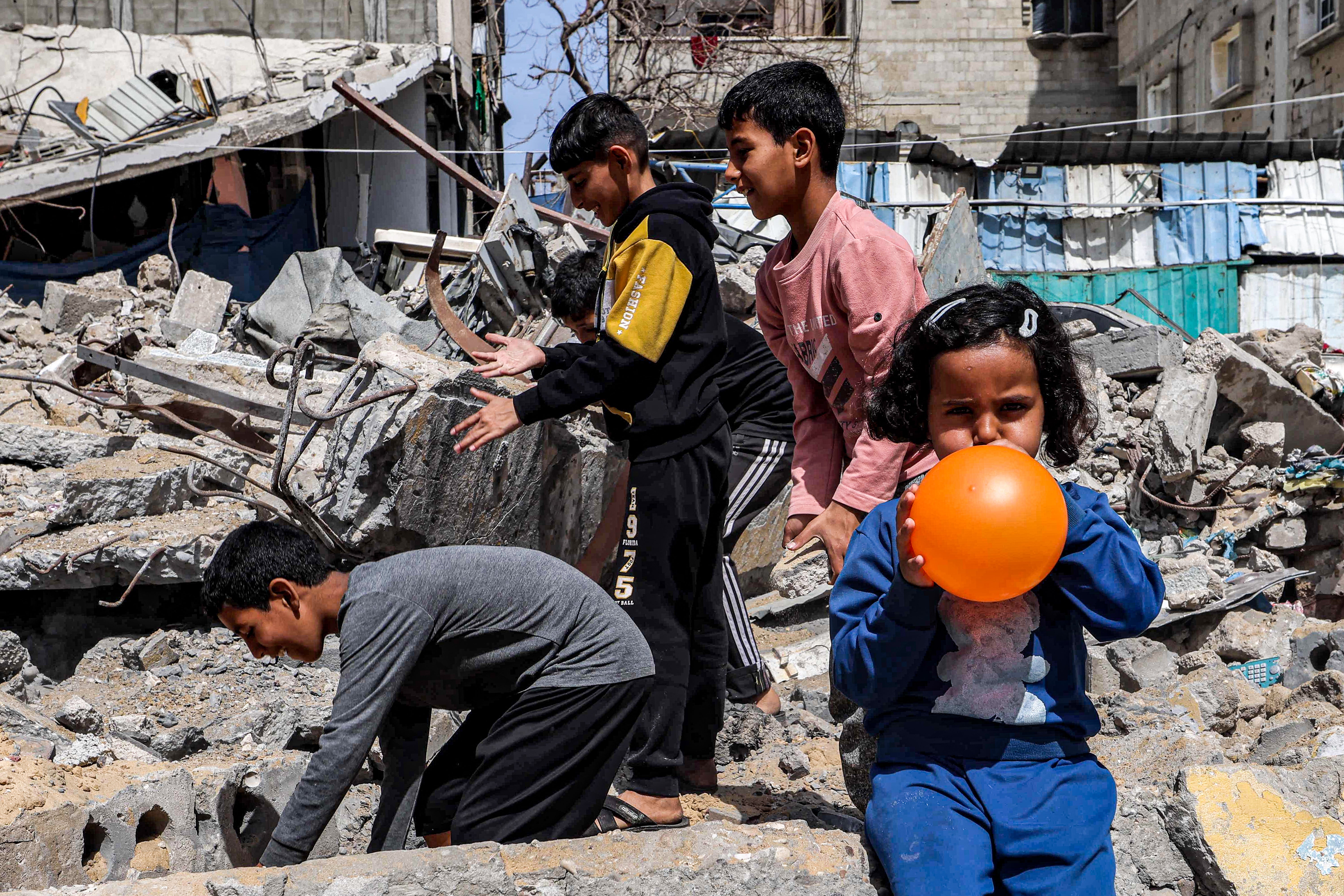 Palestinian children play amongst the rubble in Rafah