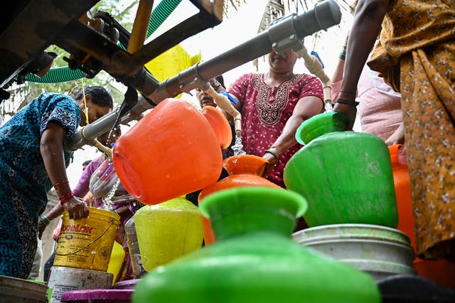 <p>People collect water from a municipal tanker in Bengaluru</p>