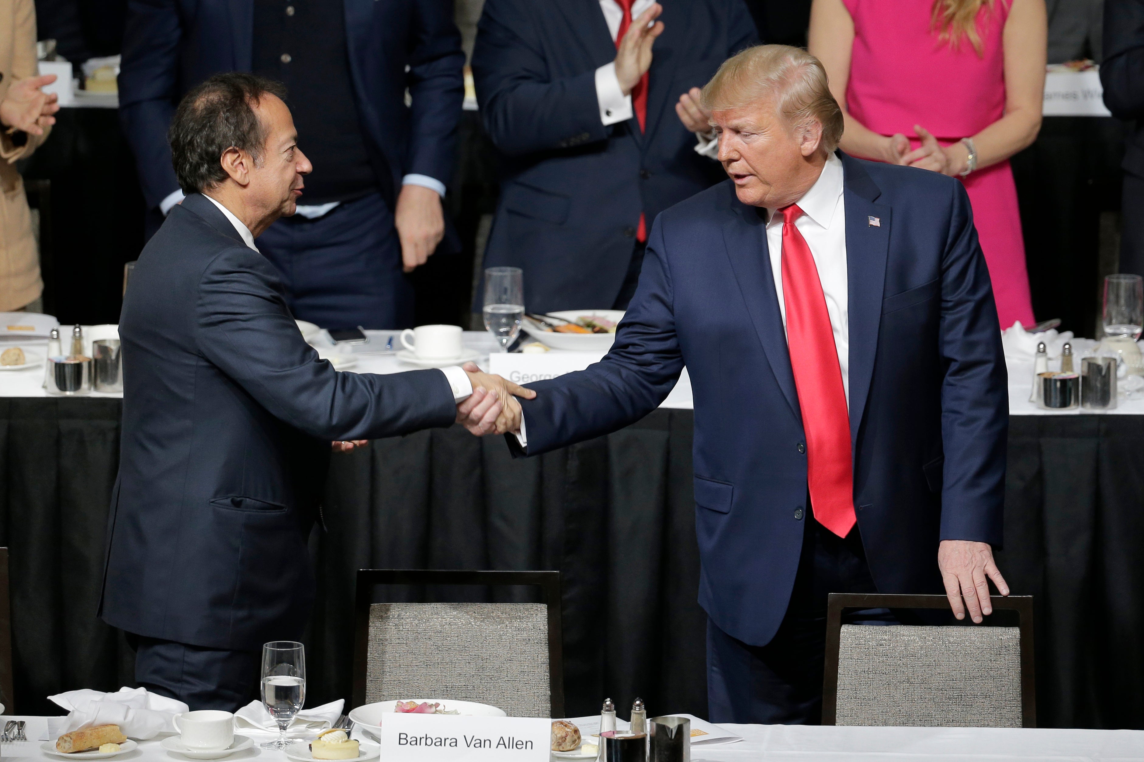 Donald Trump shook hands with John Paulson during a meeting of the Economic Club of New York in November 2019. Mr Paulson is hosting a fundraiser for the Trump campaign on Saturday