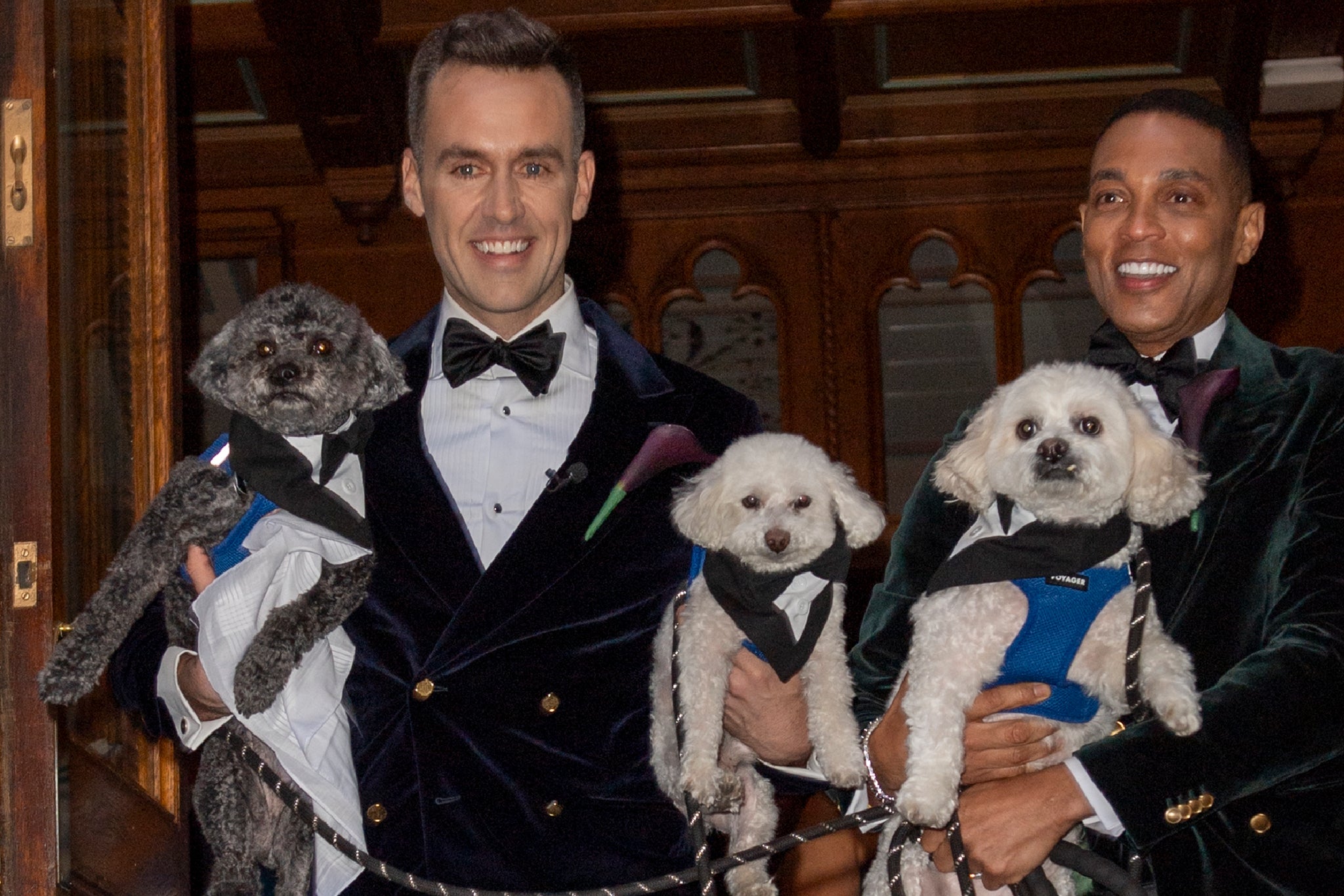 Don Lemon and Tim Malone holding their dogs as they exit the ceremony