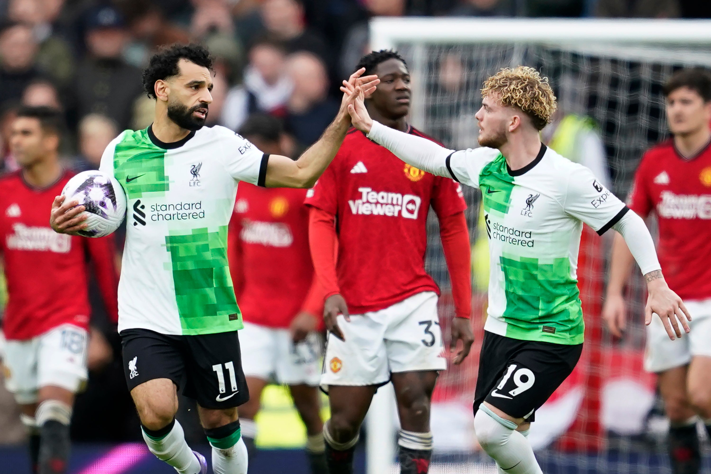 Liverpool's Mohamed Salah, left, celebrates with Harvey Elliott after scoring his side's second goal against Manchester United