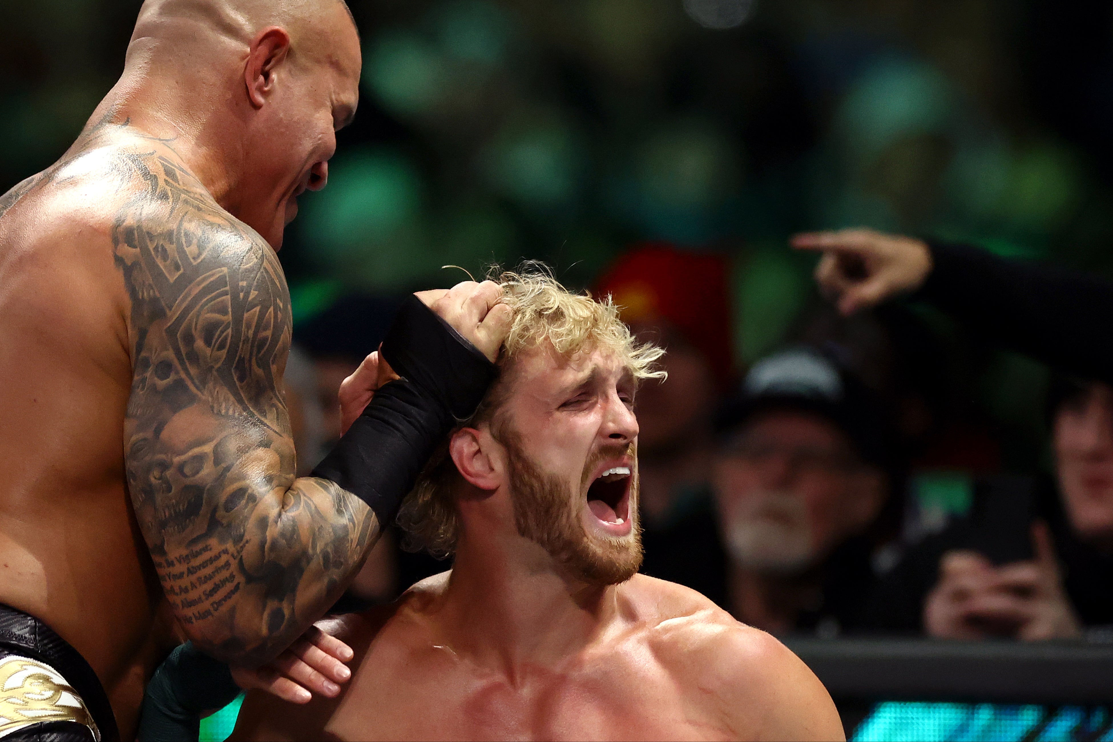 Logan Paul is attacked by Randy Orton (left)