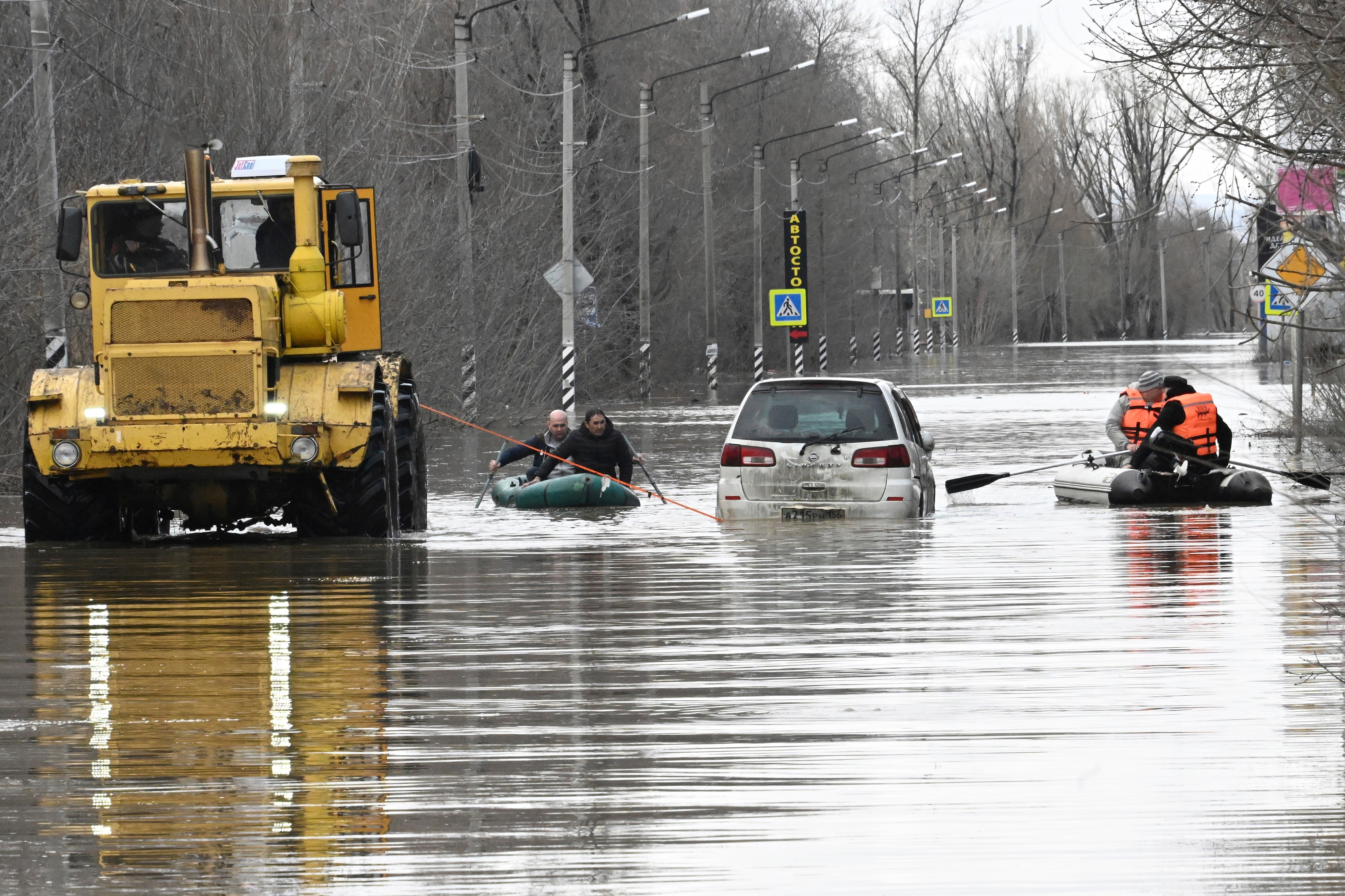 People use rubber boats to cross a flooded street in Orsk