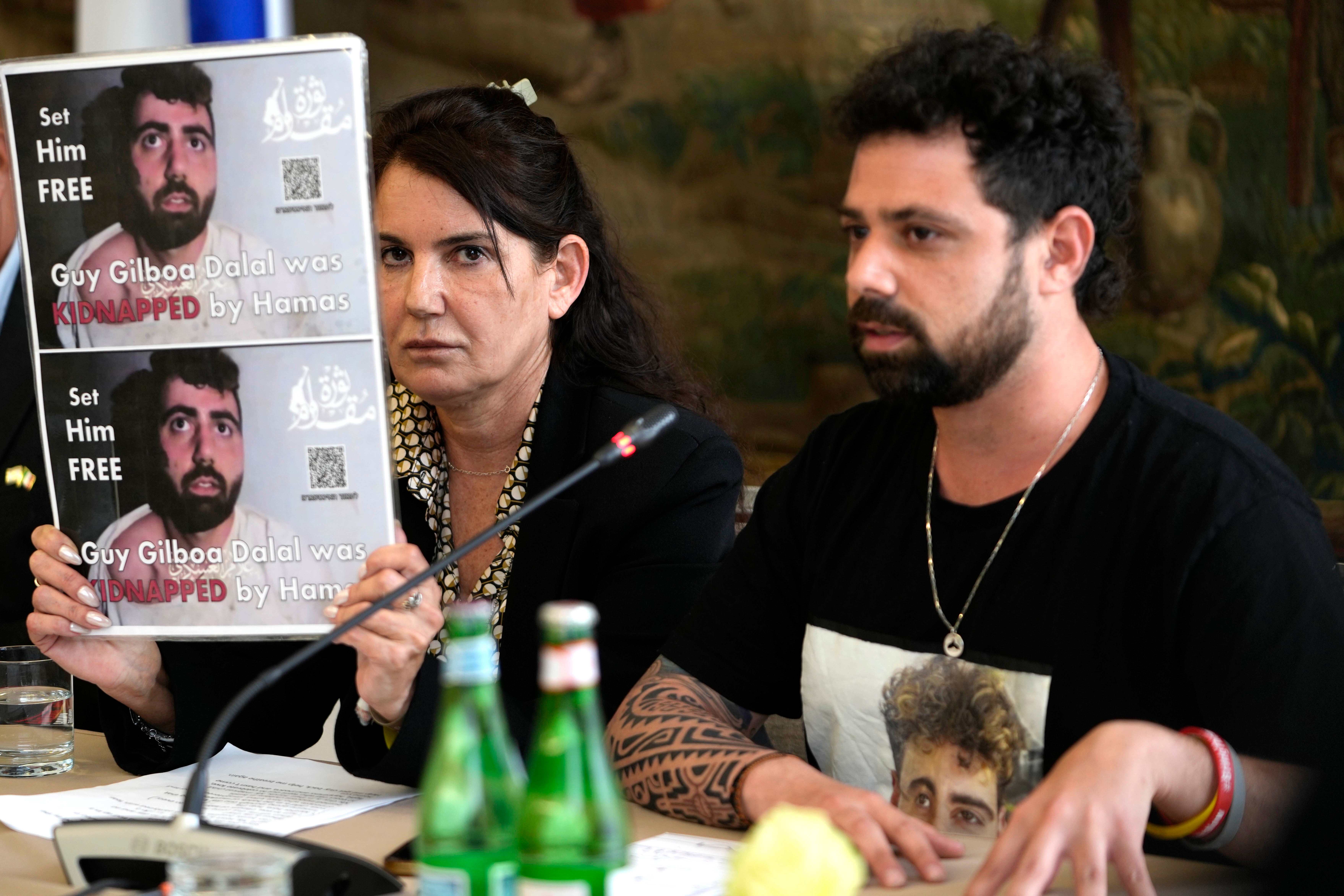 Meirav Gilboa-Dalal, left, shows a photo of her son Guy, one of the hostages being held by Hamas