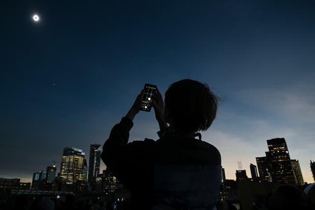 <p>A young man views the solar eclipse in Montreal </p>