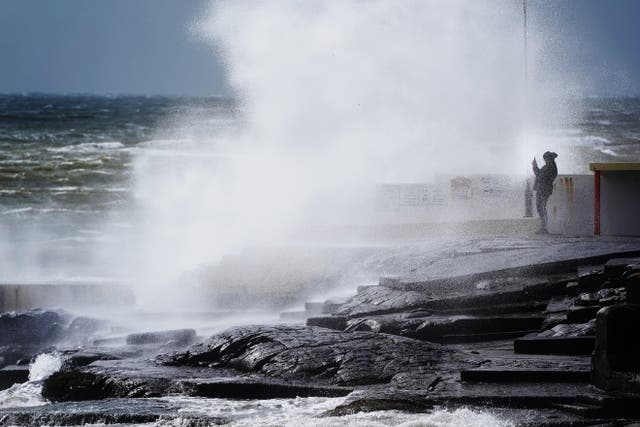 <p>A man takes photos of the waves as Storm Kathleen rages on</p>